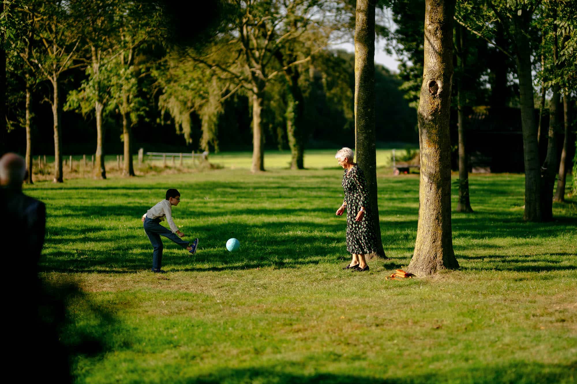     Beschrijving: Een vrouw speelt een spel met een bal in een park.