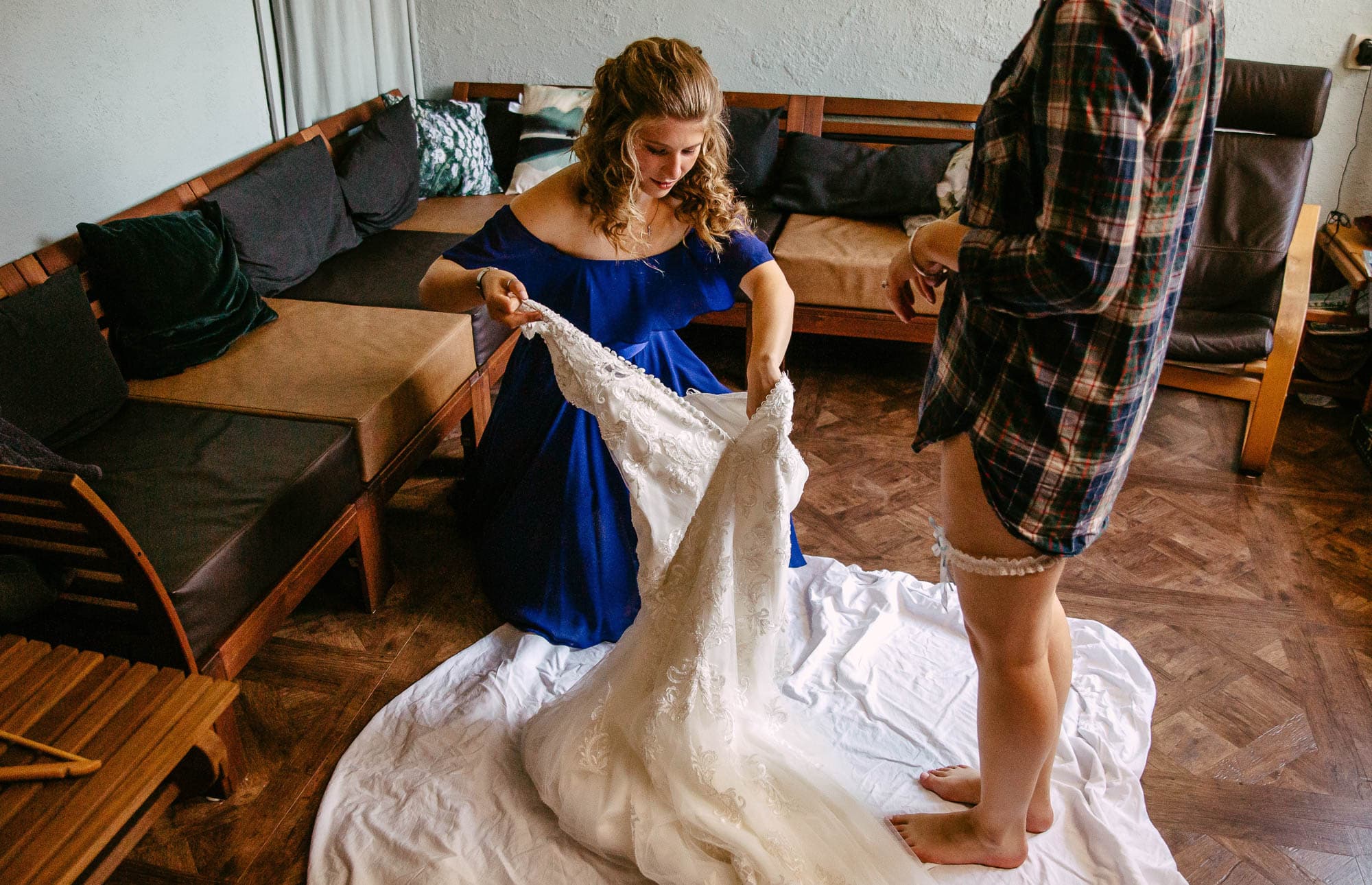 Een bruid bereidt haar trouwjurk voor met behulp van een ceremoniemeester.