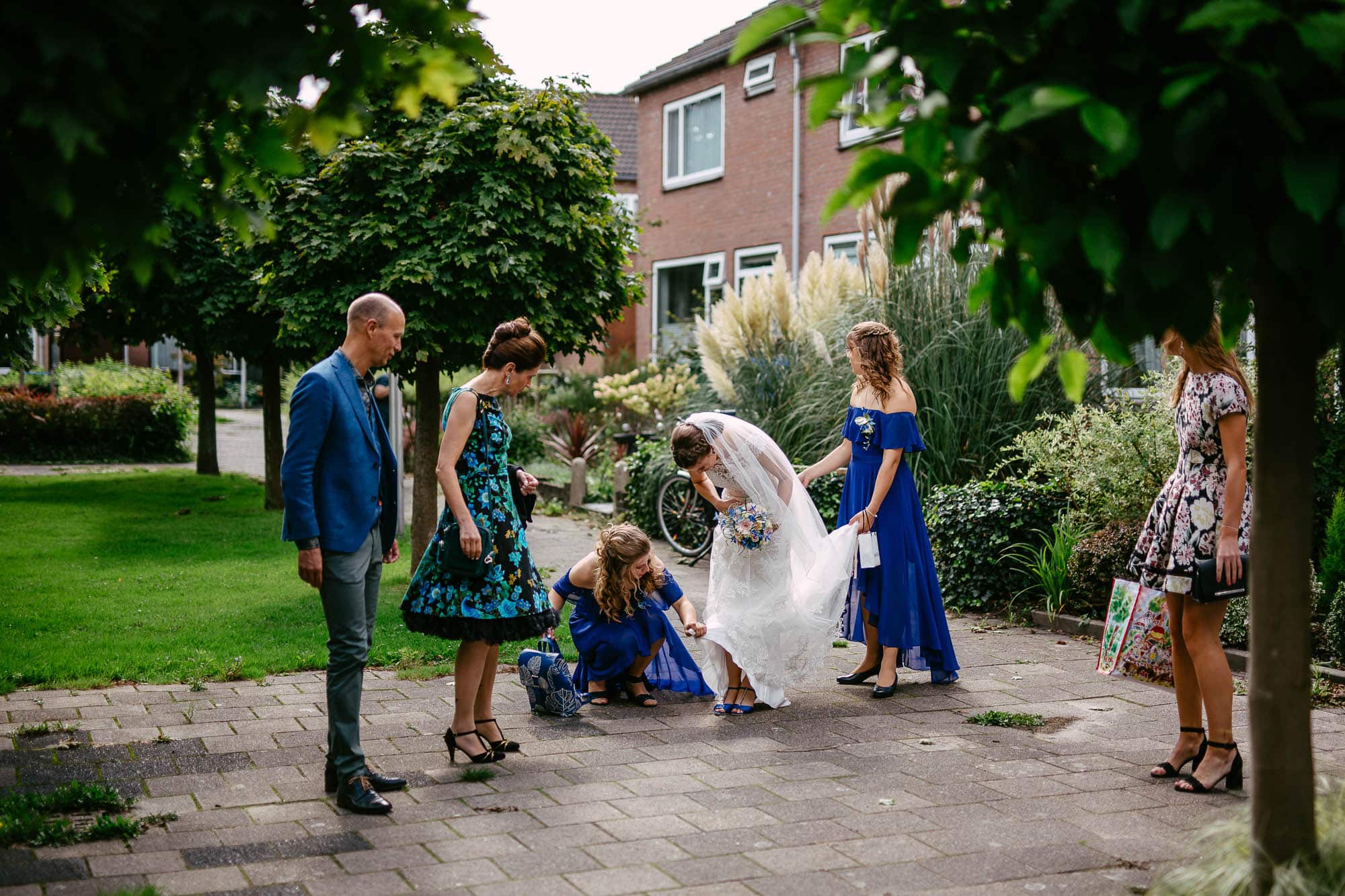 Een bruid en haar bruidsmeisjes maken zich in een tuin klaar voor hun ondertrouw.