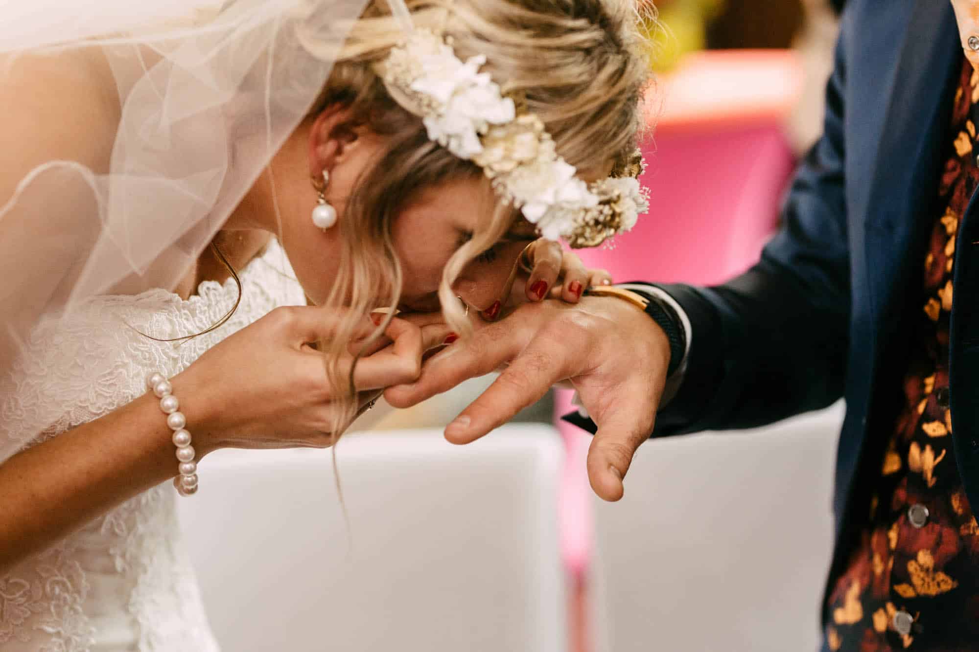 Een bruid en bruidegom die een romantische kus delen tijdens hun huwelijksceremonie in Het Koetshuis Rotterdam.
