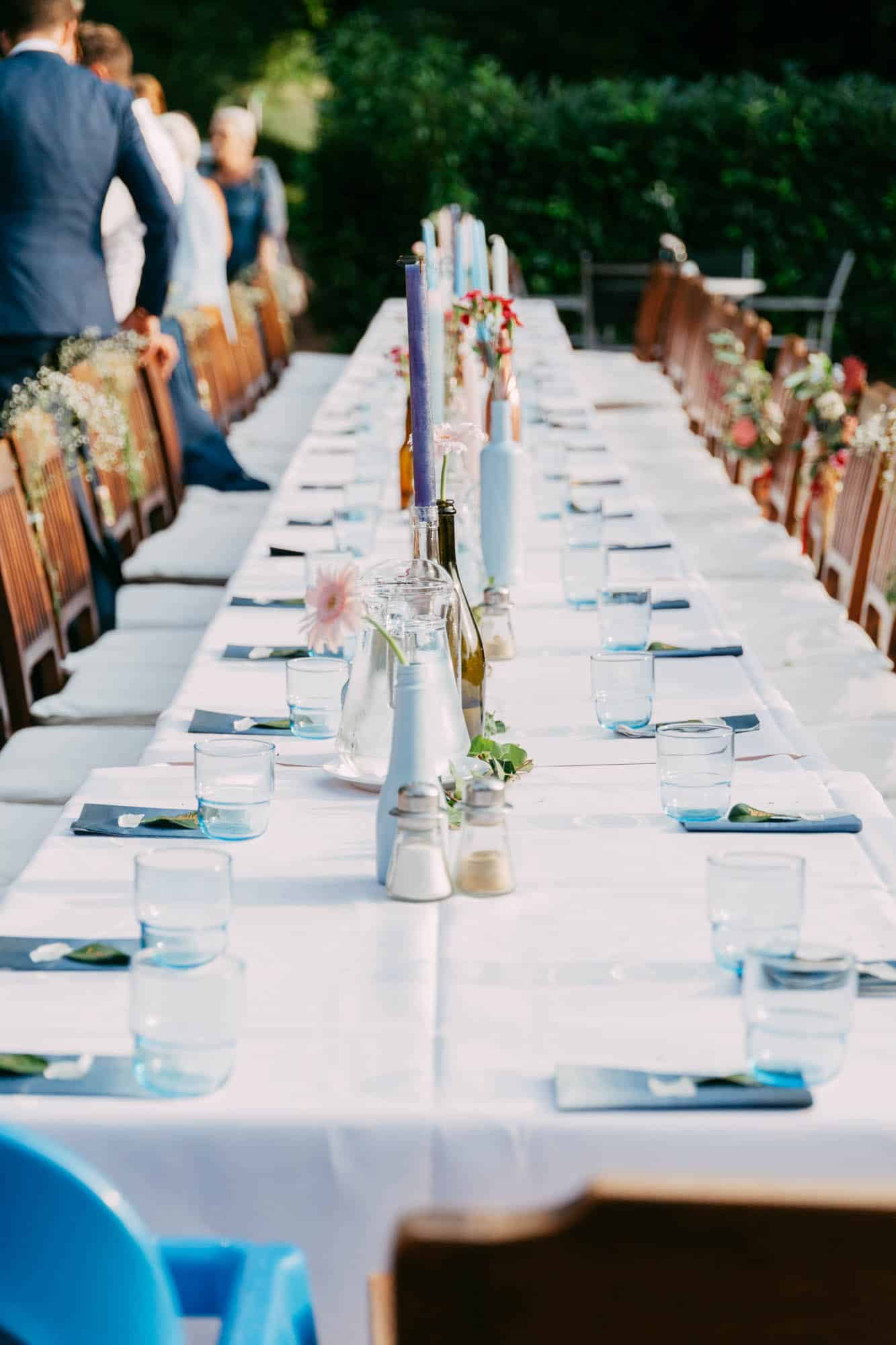     Beschrijving: Een lange tafel opgezet voor een bruiloftsfeest.
