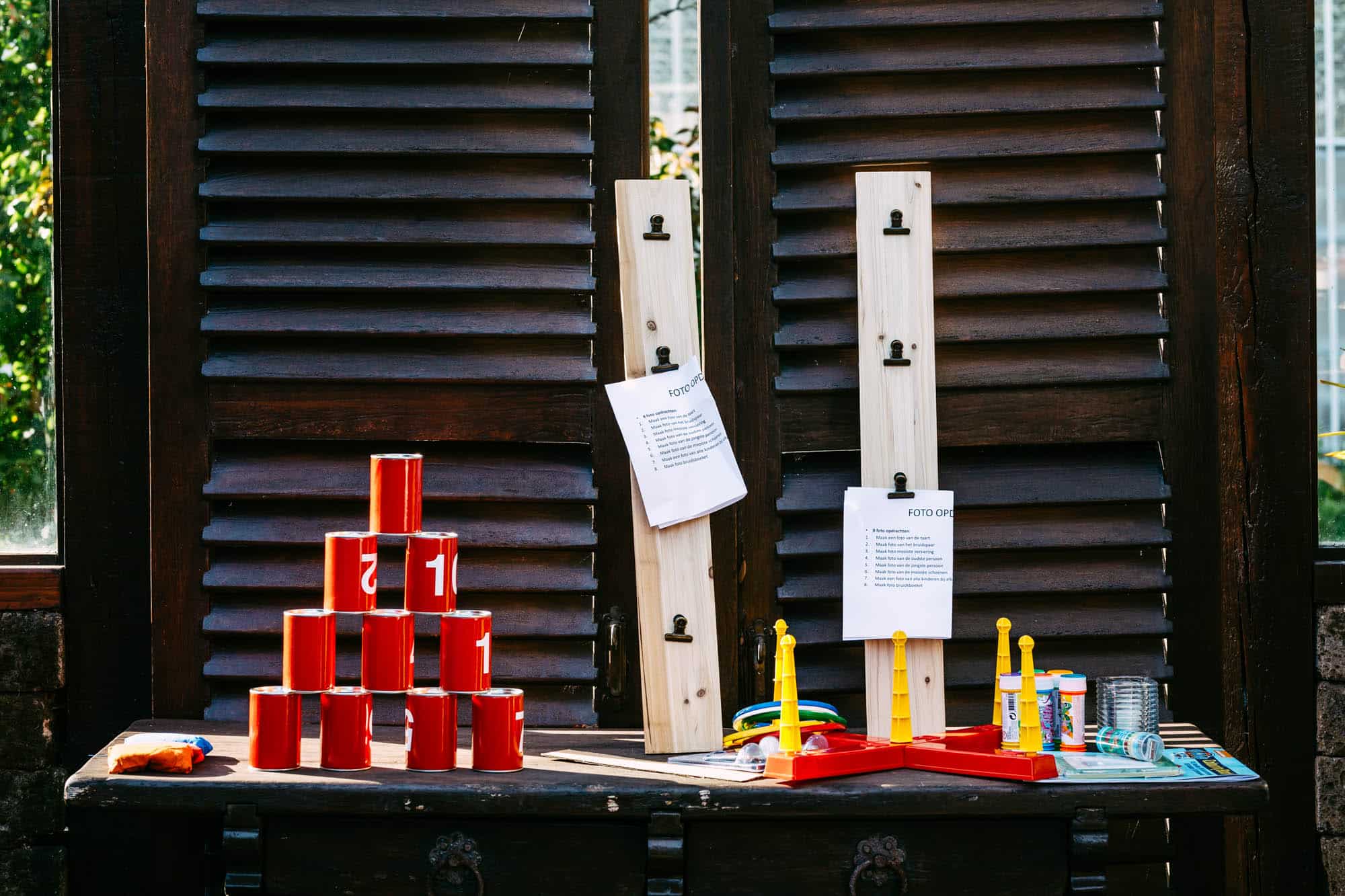 A wooden table with candles and a wooden board to use for wedding games.