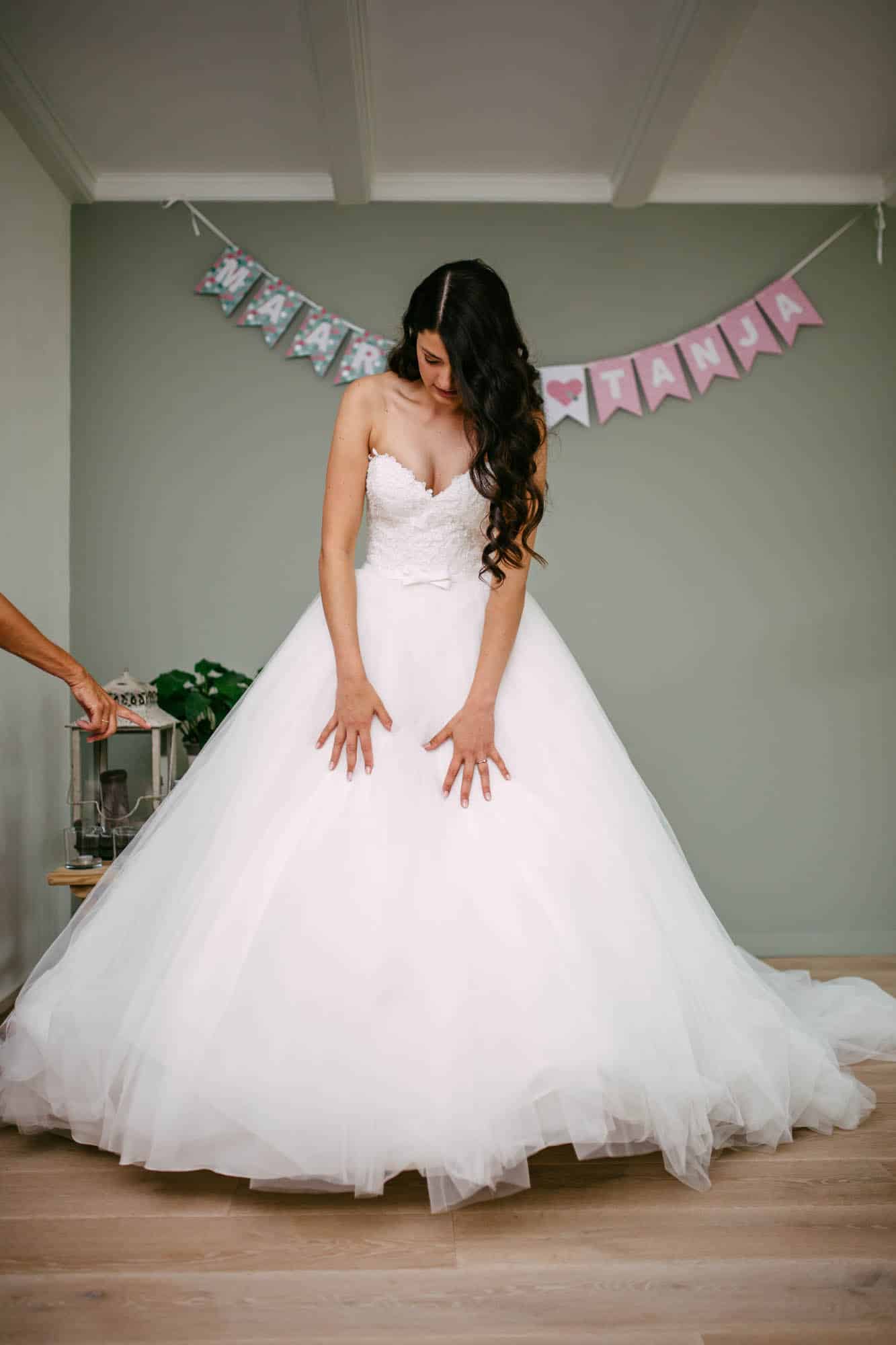 A bride wearing an A-line wedding dress in a room.