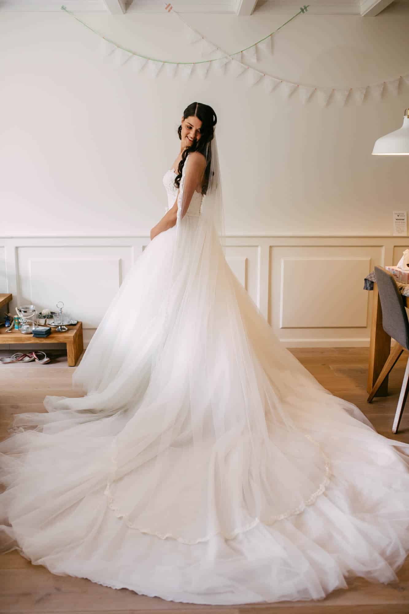 A bride wearing a beautiful A-line wedding dress looks graceful in a room.