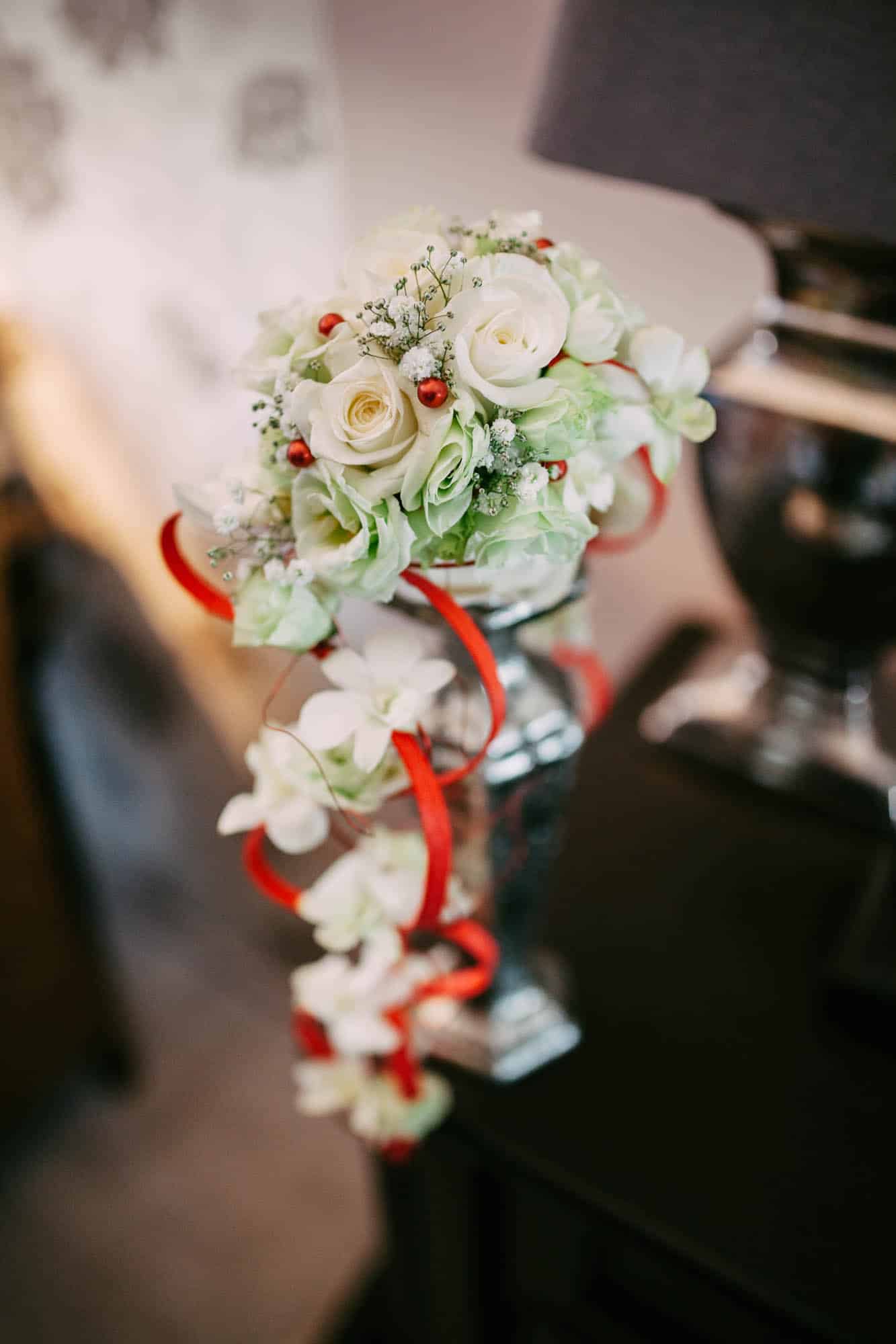On a table is a white and red Wedding Bouquet.