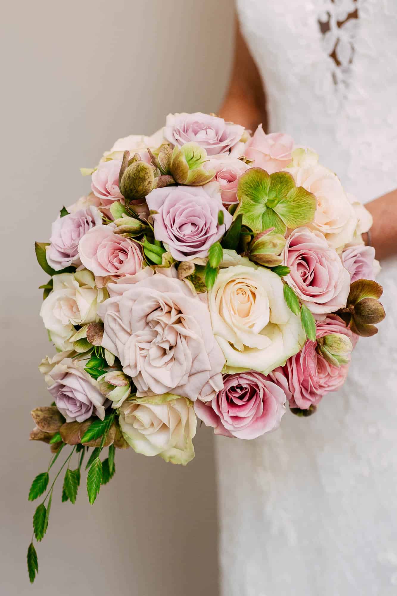 A bride loves a wedding bouquet of pink and white roses.