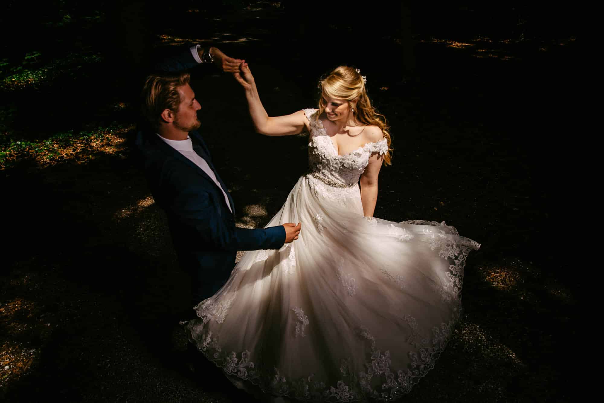 A bride in a beautiful A-line wedding dress and her groom dance gracefully through the enchanting forest.