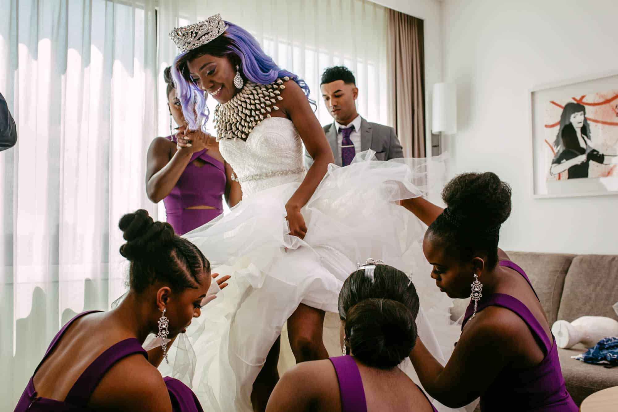 Een bruid in haar A-lijn trouwjurk maakt zich klaar met haar bruidsmeisjes.