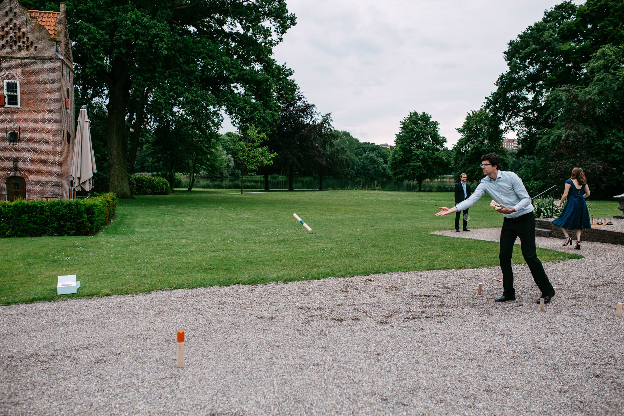 A man playing Frisbee in a park during a wedding match.