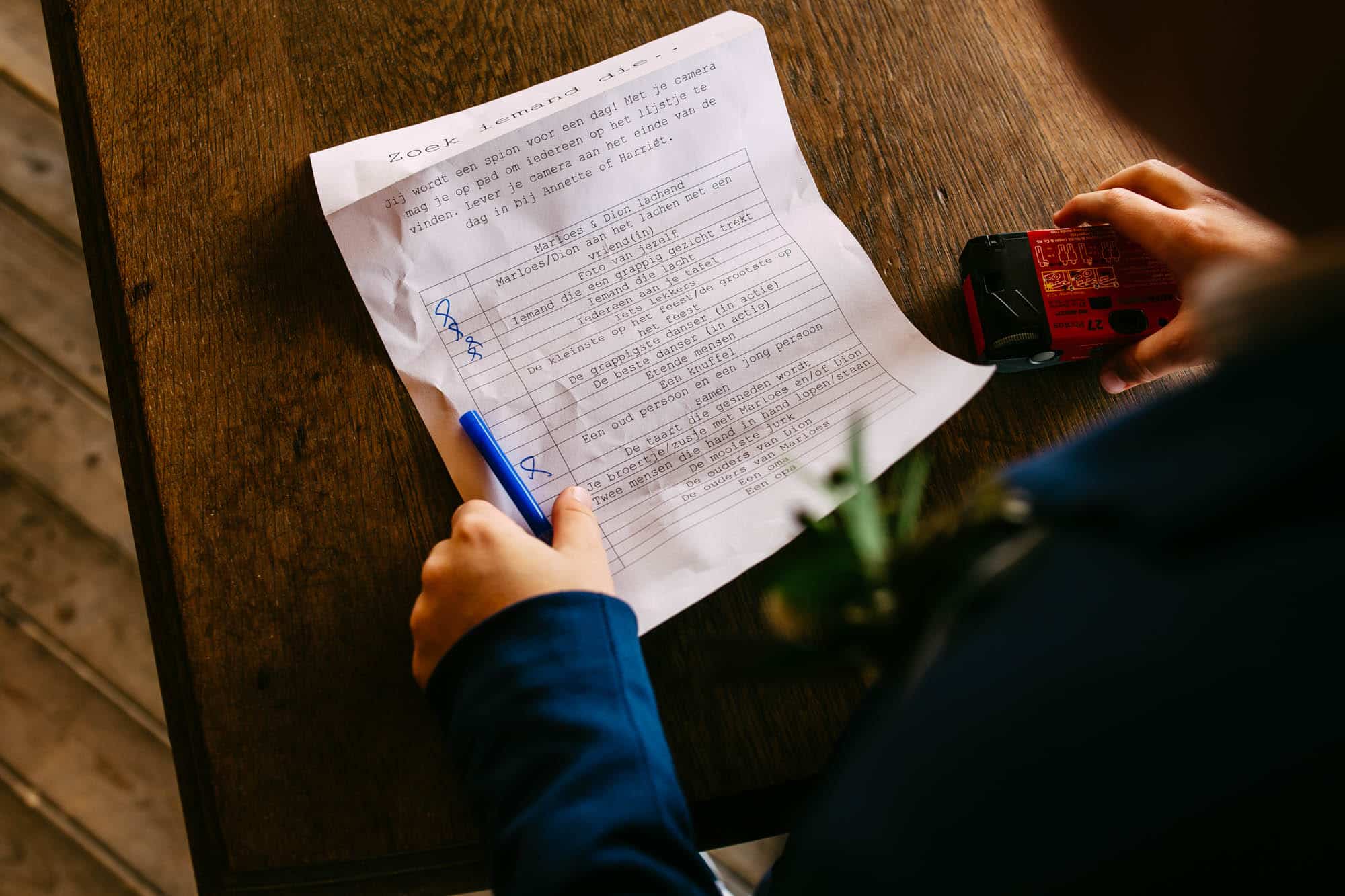 Een persoon die tijdens een bruiloft op een stuk papier schrijft.