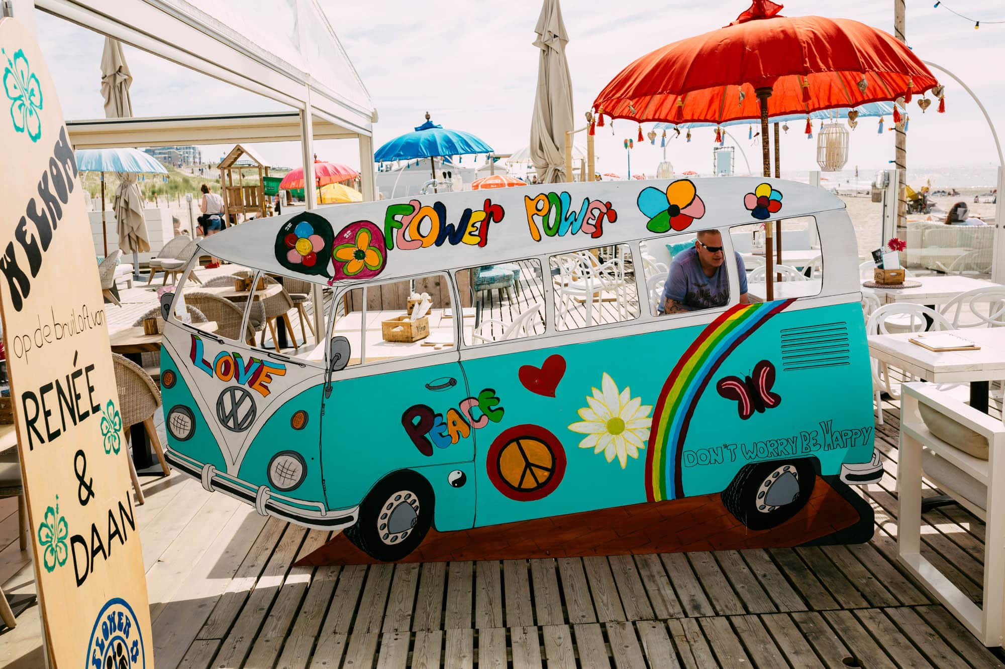 A VW bus parked on a wooden deck, perfect for a photo booth for a bridal shower.