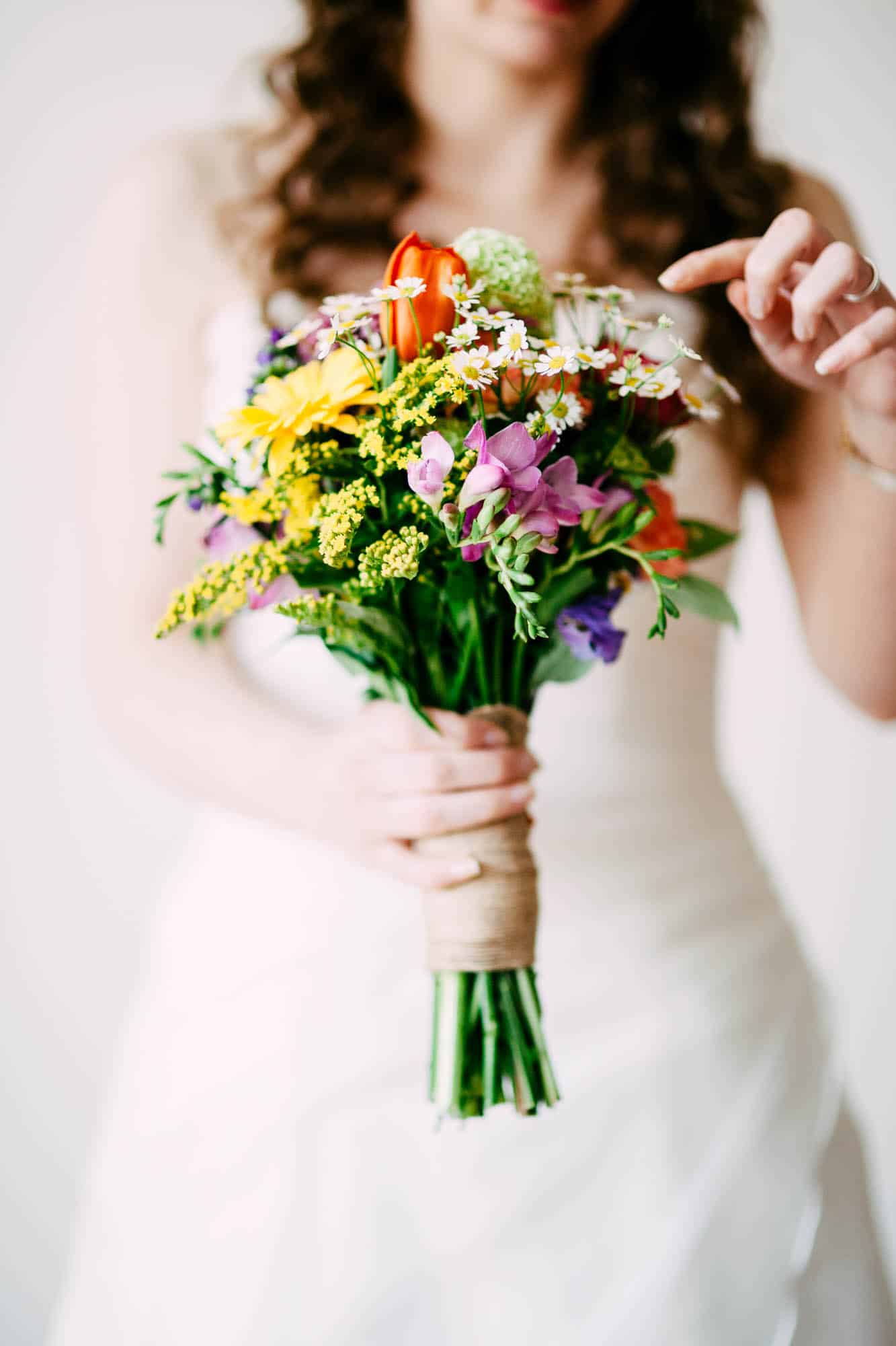     Description: A Wedding Bouquet bride holding a bouquet of colourful flowers.
