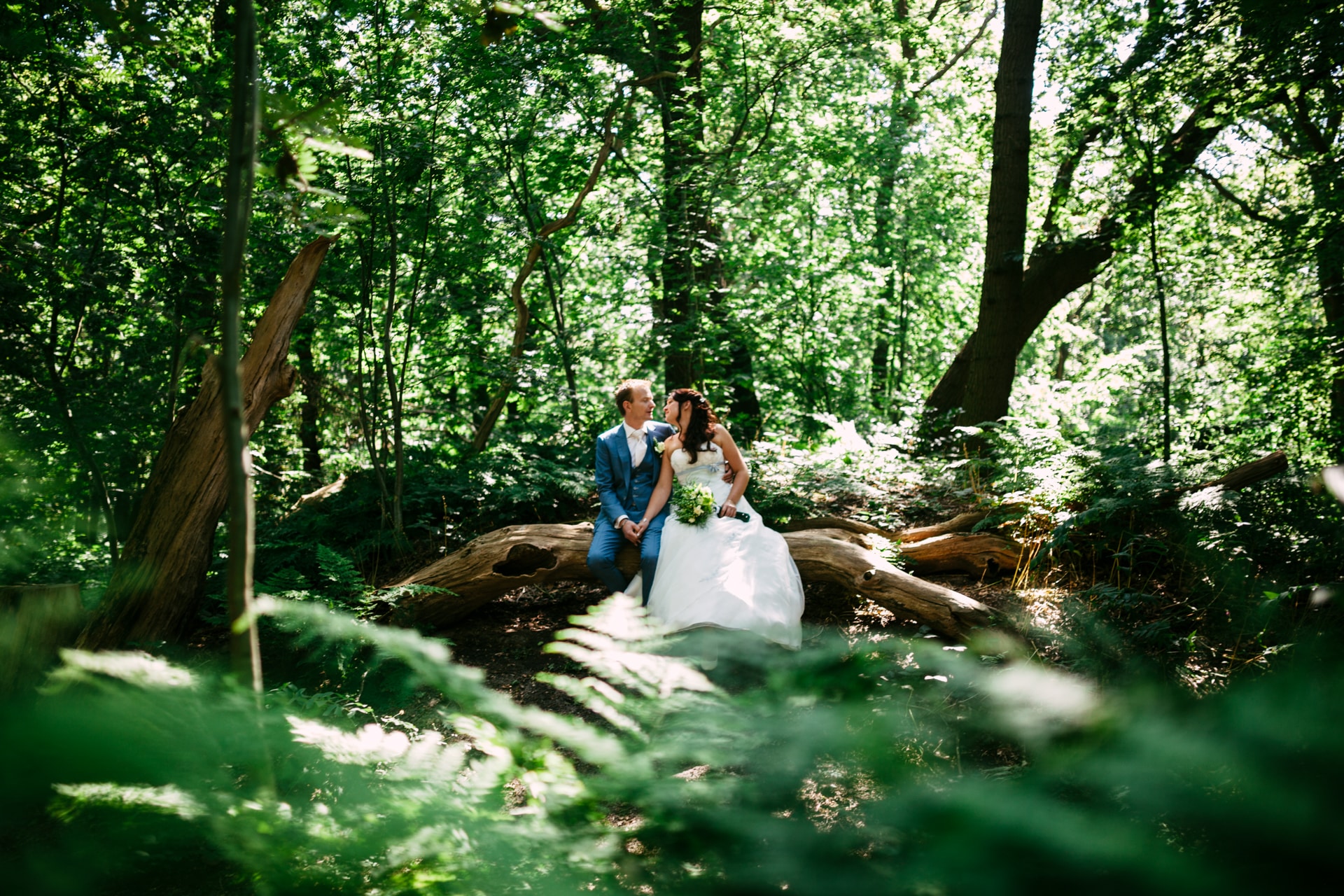 Trouwen in het bos - Een stel dat op hun trouwdag in het bos staat.