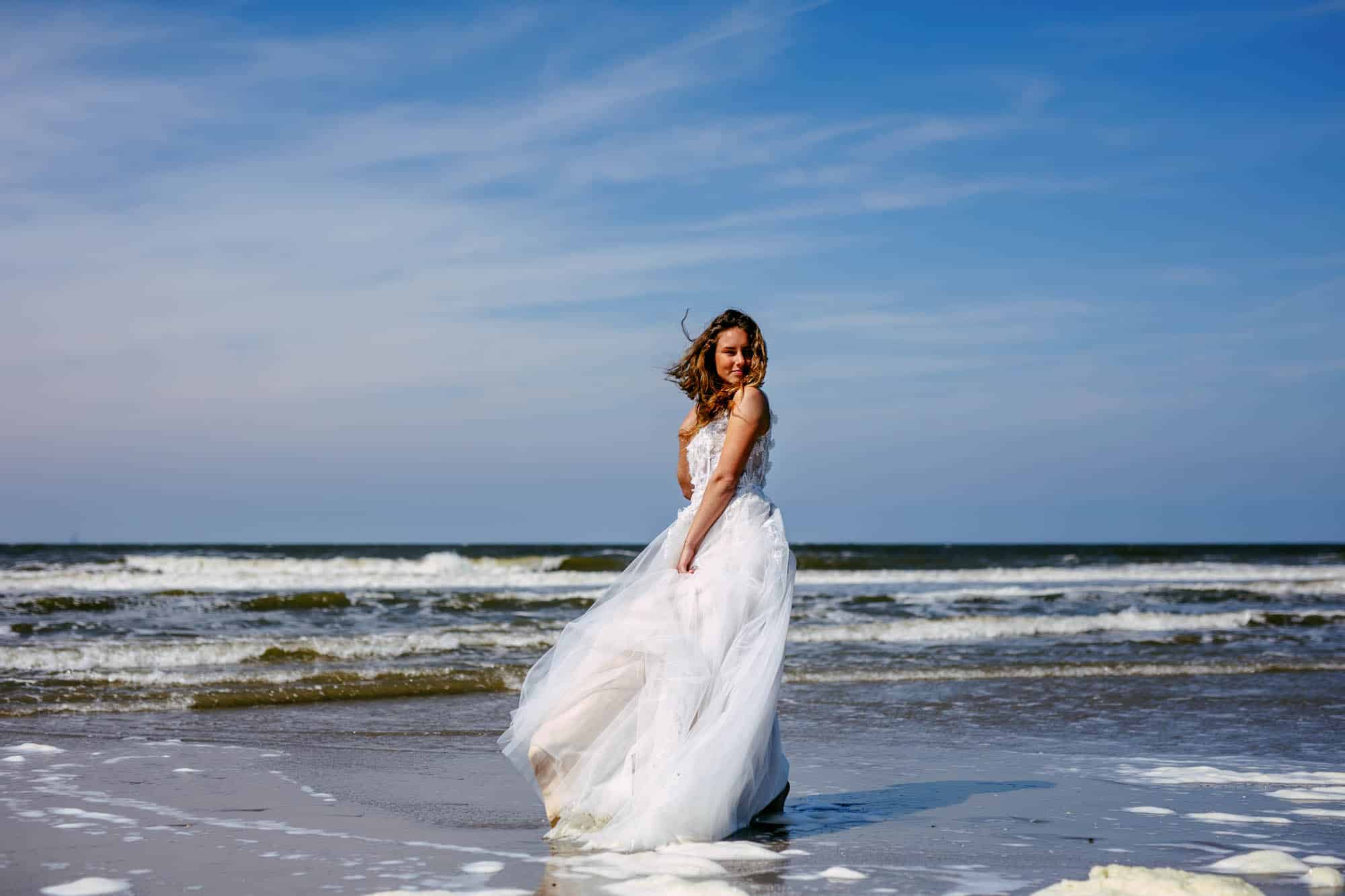 Bride with wedding dress in the sea