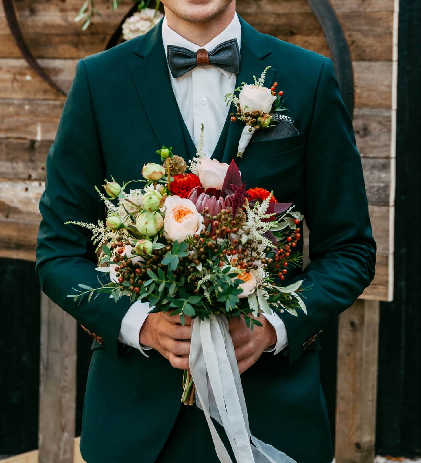 Corsage is placed on groom's blue suit.