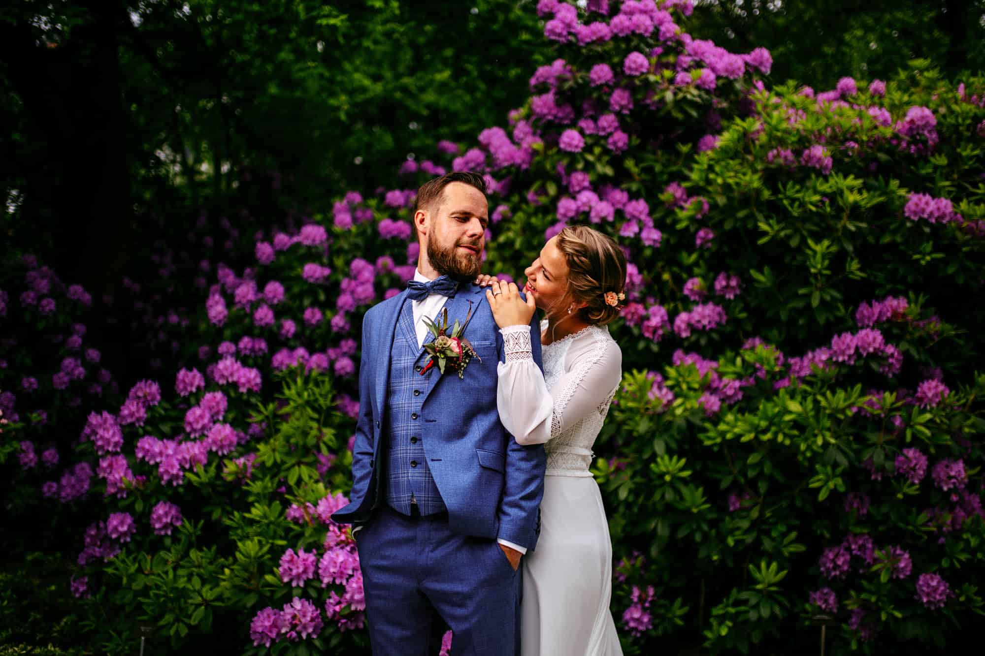 Bridal couple by a rhododendron.