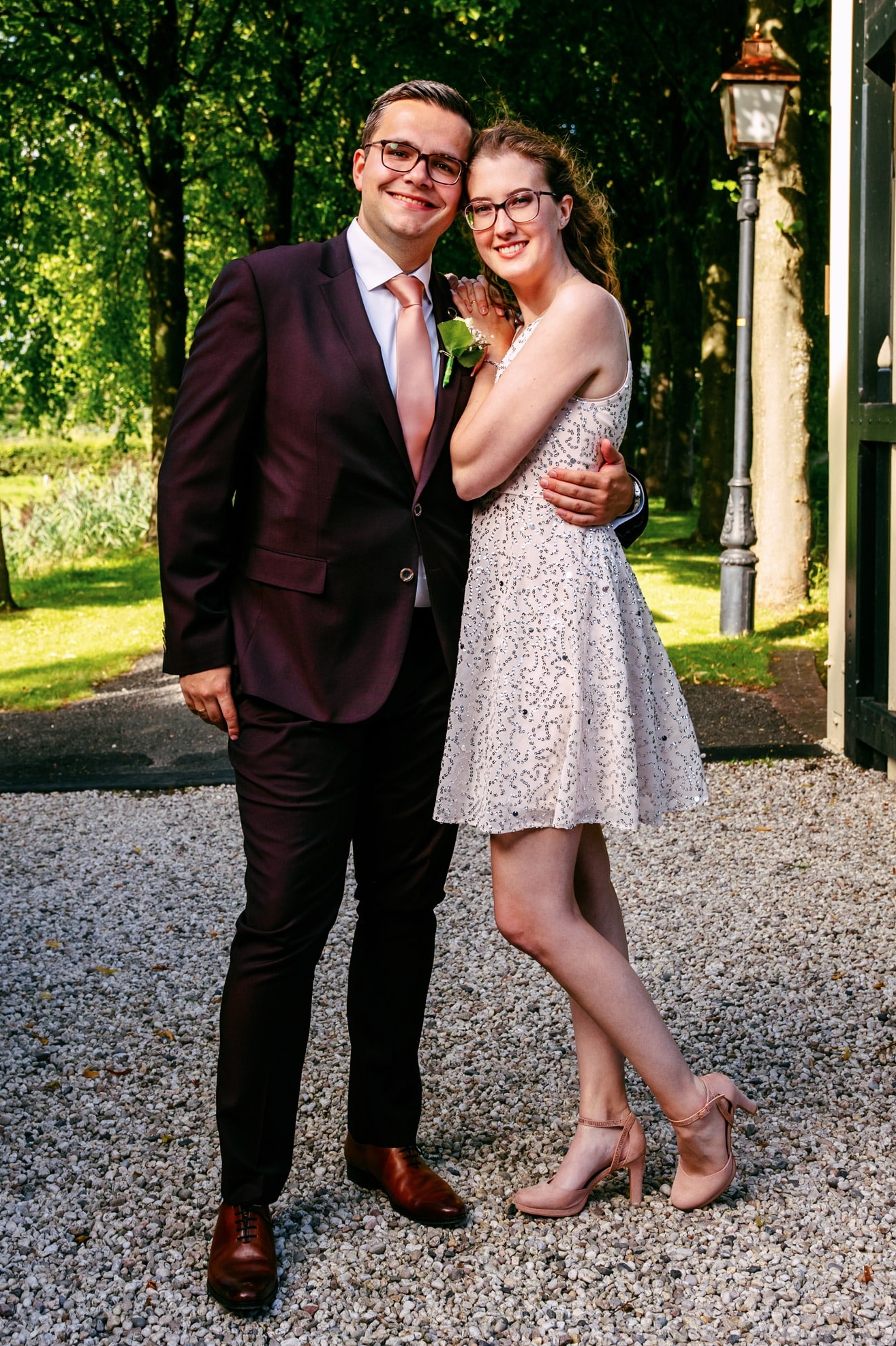 Een man in een pak en een vrouw in een jurk, beiden gekleed in casual chique kleding.