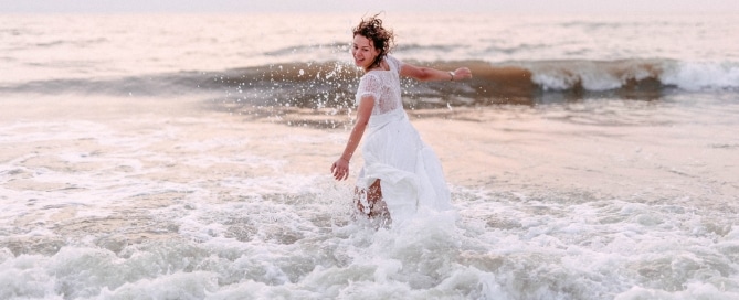 Bruid in zee voor een trash the dress fotoshoot