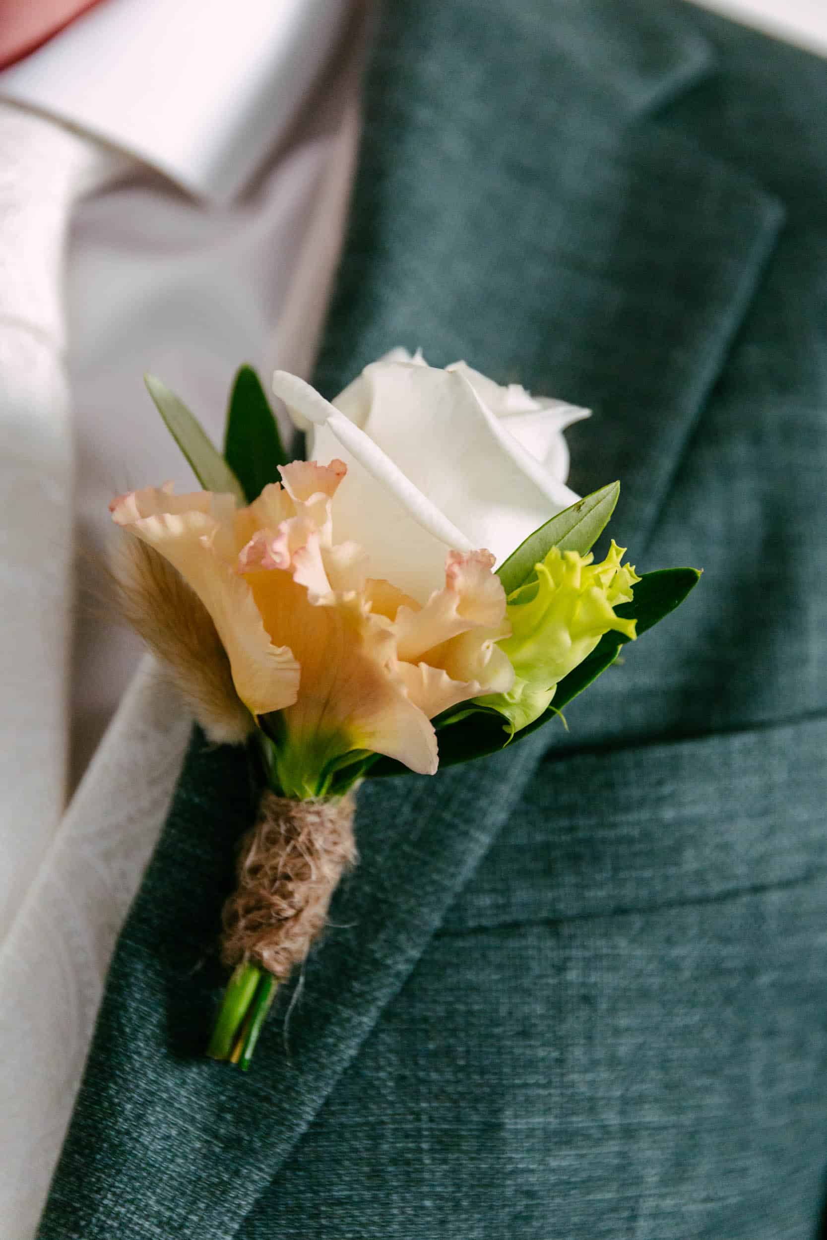 Corsage with a pink rose and plaster powder to the groom.