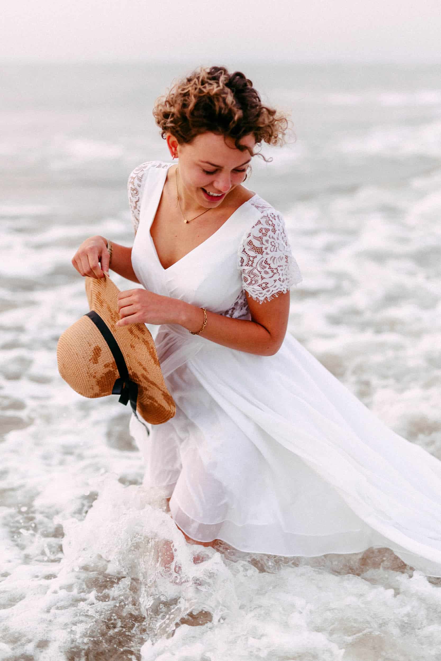 Bride with wedding dress in the sea