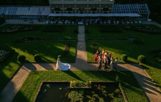 Een luchtfoto van een huwelijksfeest in een tuin, waarin de schoonheid van de ceremonie en viering wordt getoond.