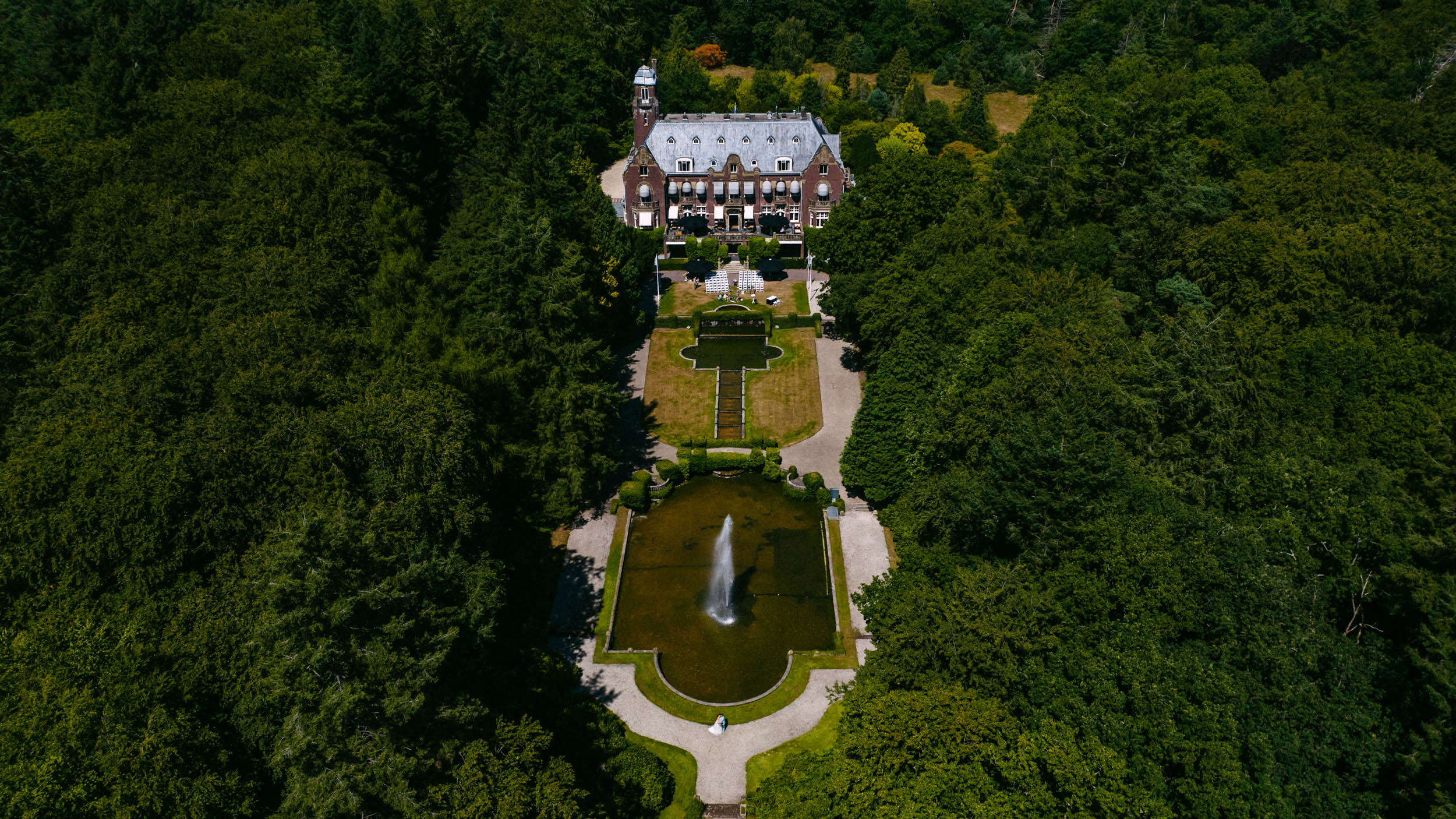 Een luchtfoto van een landhuis vastgelegd door een drone, omgeven door bomen.