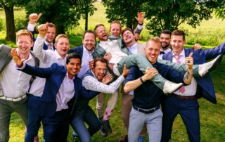 Een groep bruidsjonkers die bijzondere trouwfoto's maken.