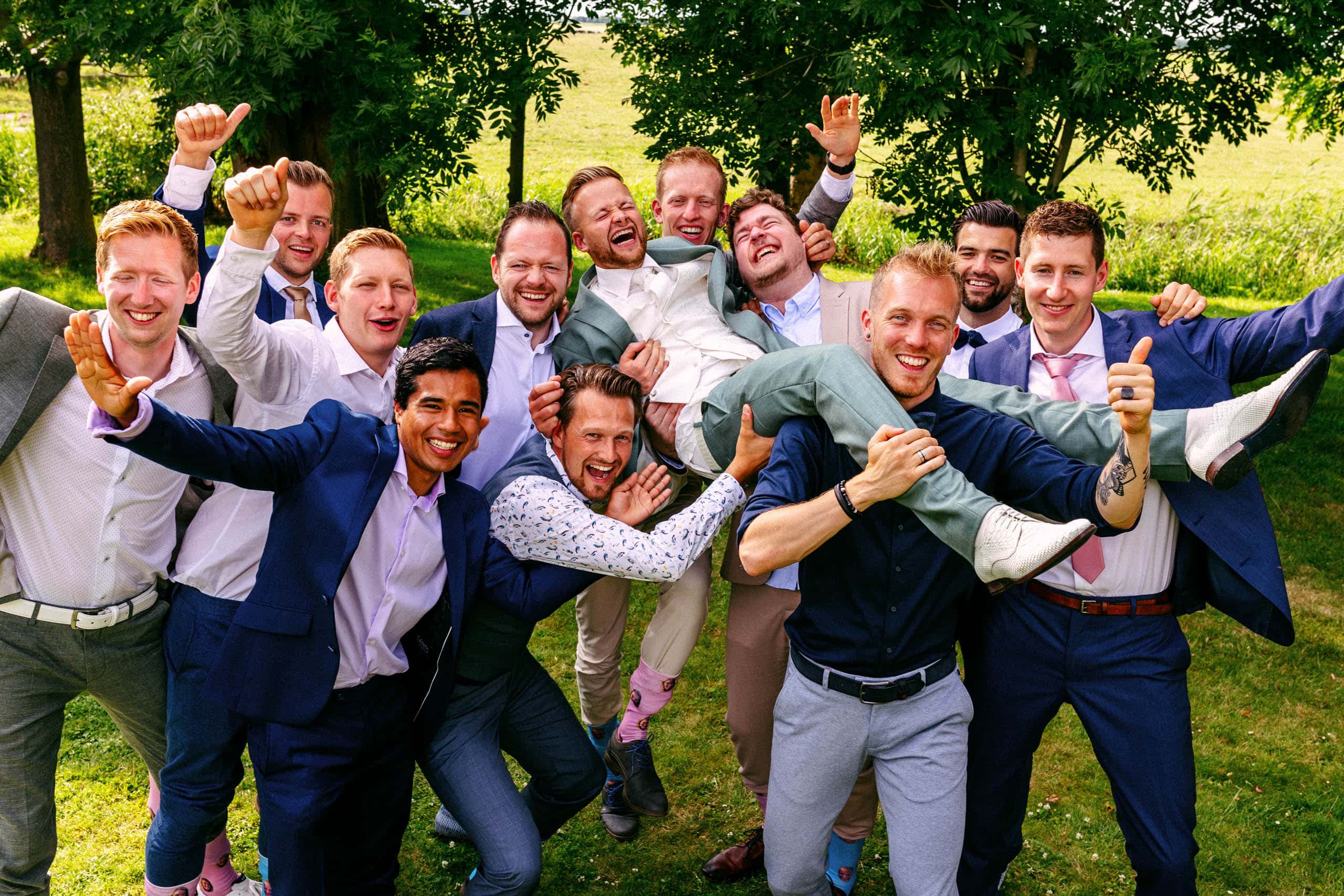 Een groep bruidsjonkers die bijzondere trouwfoto's maken.