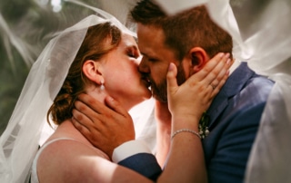 Trouwfoto's van een bruid en bruidegom die elkaar kussen onder een sluier.