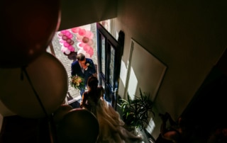 Een bruid en bruidegom die met ballonnen door de gang lopen en bijzondere trouwfoto's maken
