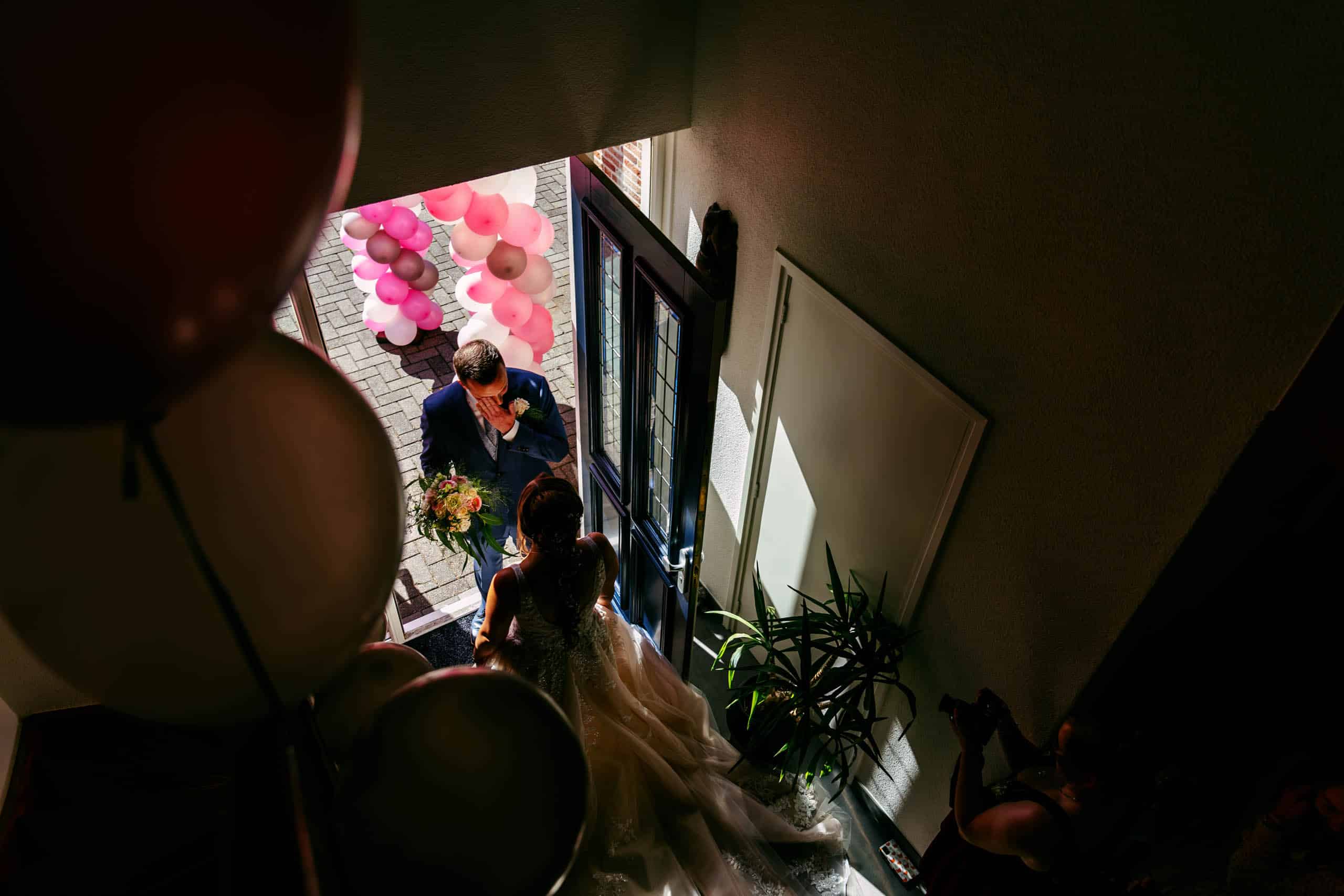 Een bruid en bruidegom die met ballonnen door de gang lopen en bijzondere trouwfoto's maken