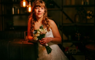 Een bruid die een boeket vasthoudt in een donkere kamer tijdens haar trouwfoto's.