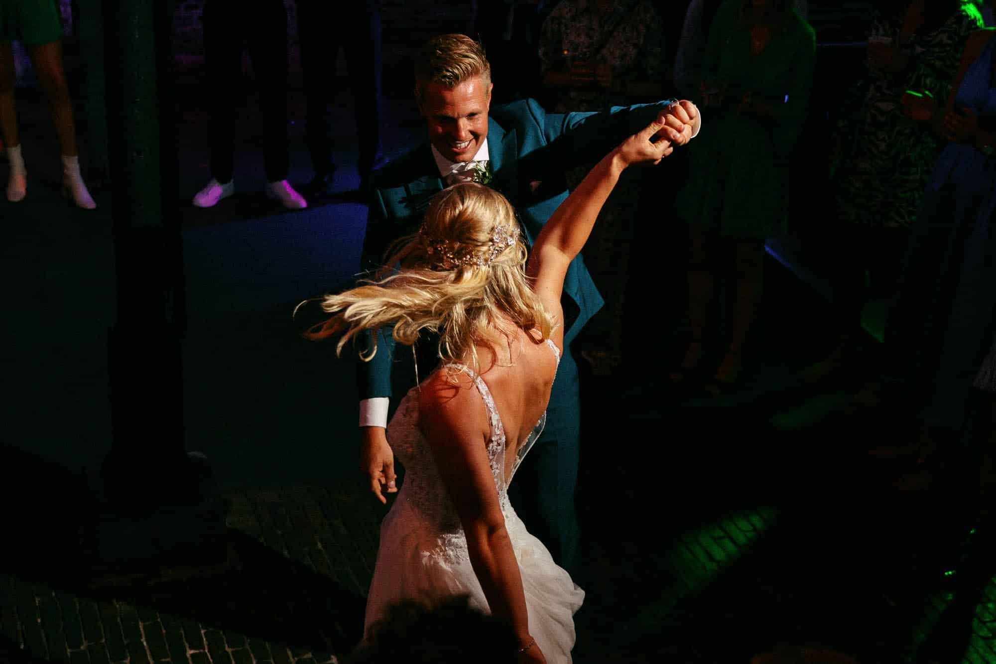 Hollandse bruid en bruidegom dansen op een feest.