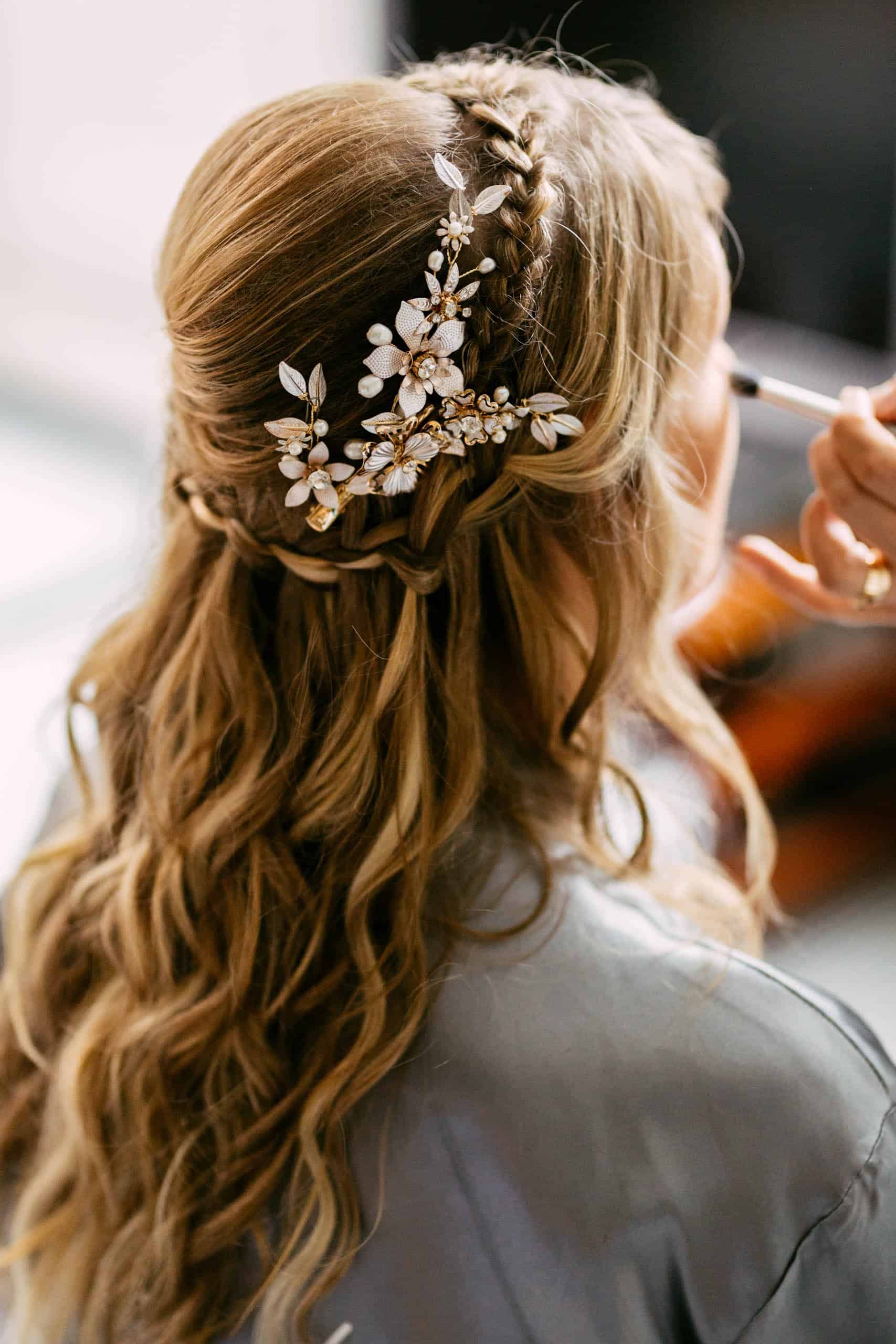 A bride getting her hair done in preparation for her wedding.