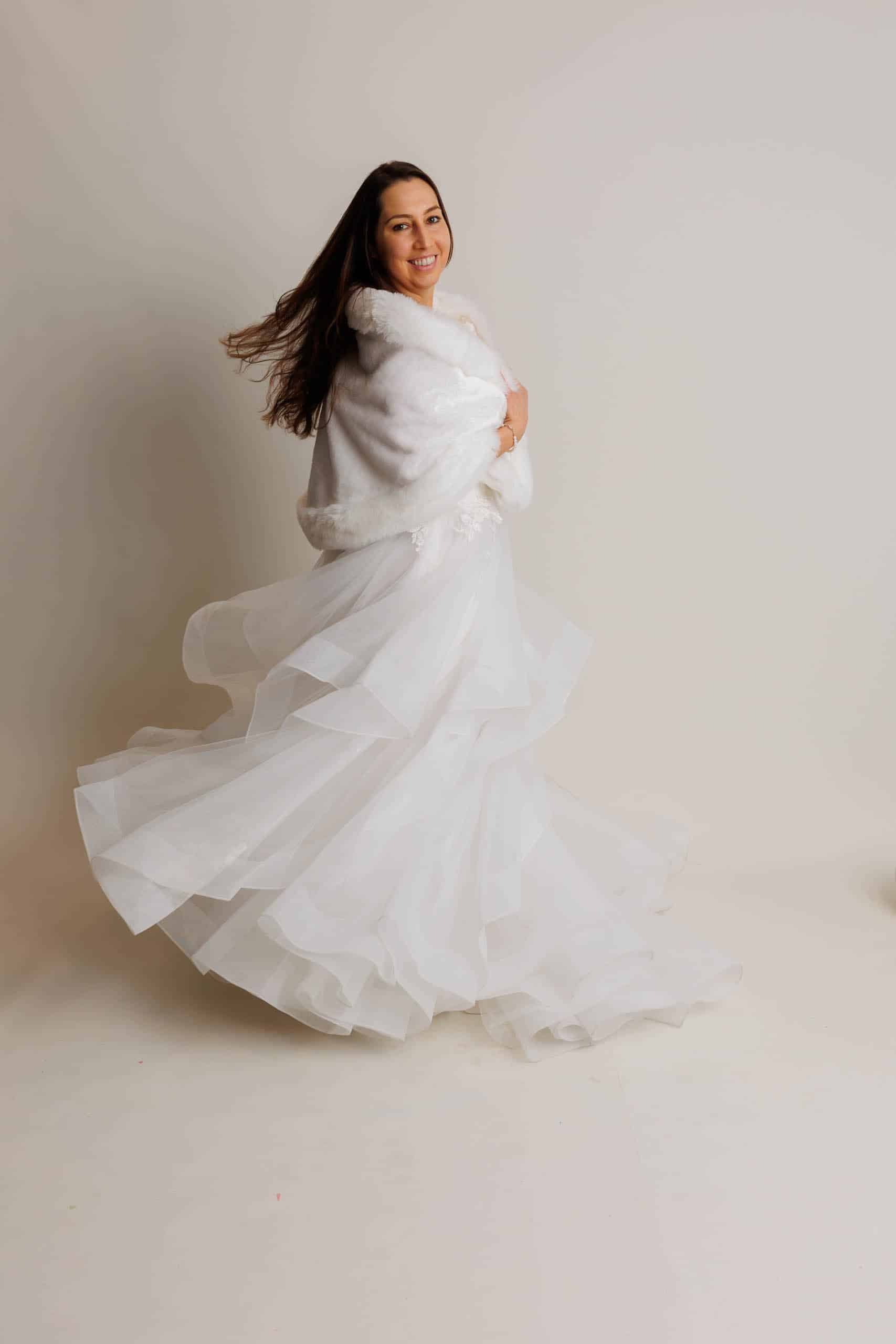 Een vrouw in een witte jurk poseert voor een foto tijdens het passagiers van trouwjurken.