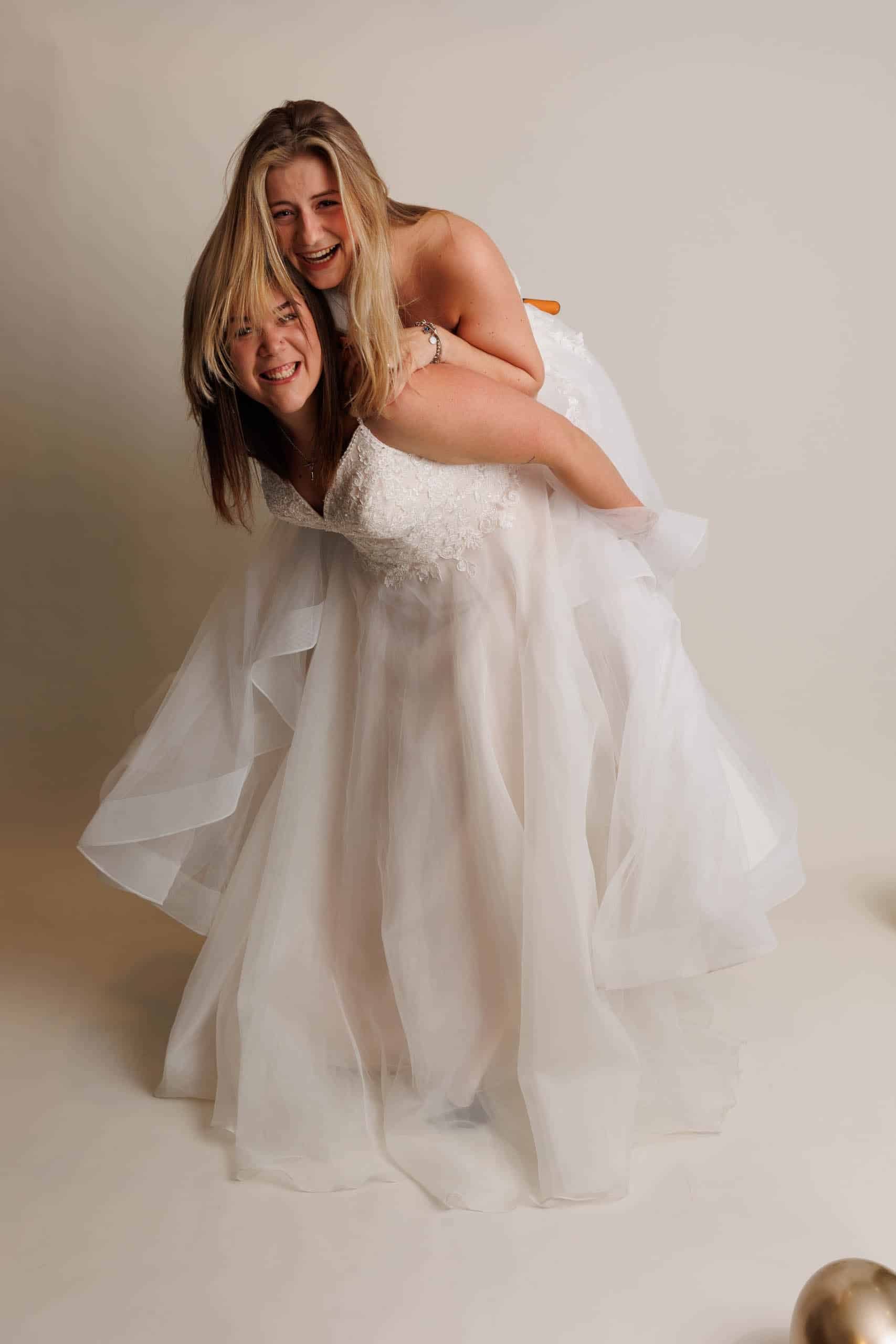 Description: Two women in wedding dresses for a photo as a joke.