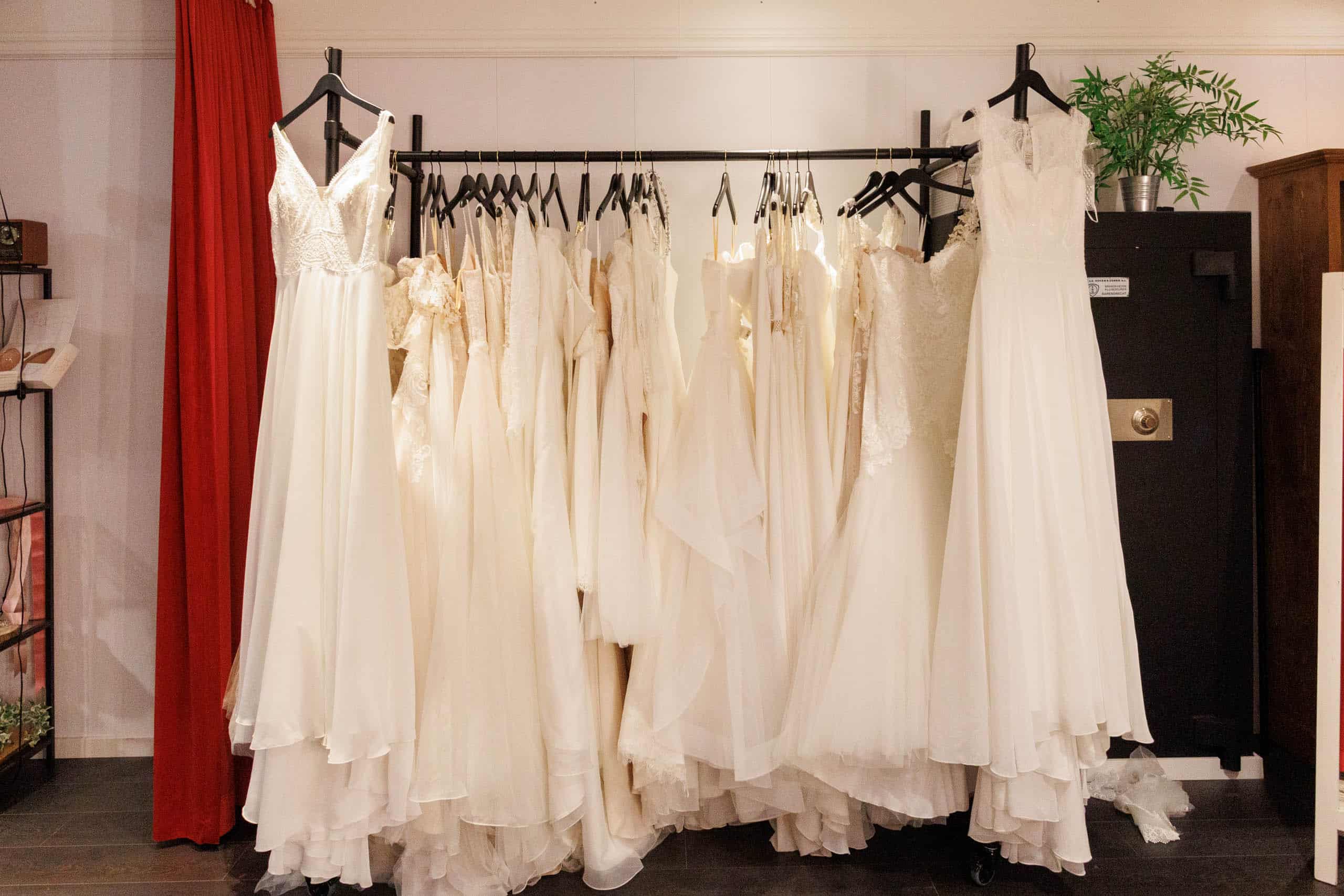Wedding dresses hanging on a rack in a room, available to try on or for fun.
