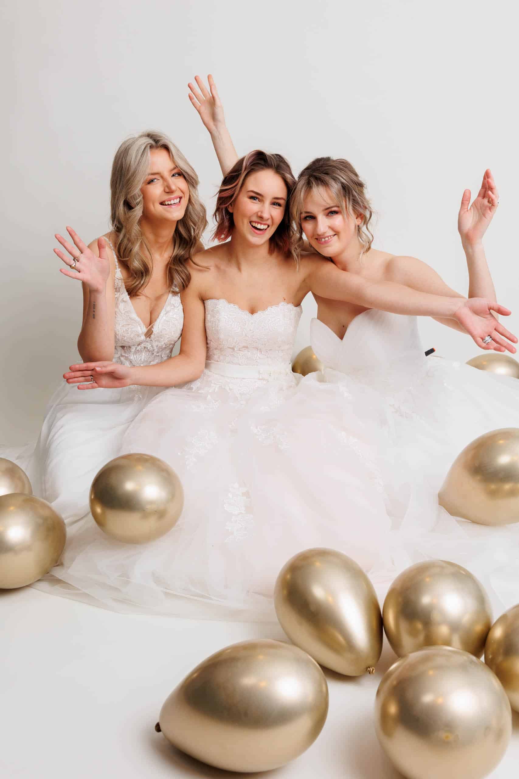 Three bridesmaids pose with gold balloons during their bachelorette party assignments.
