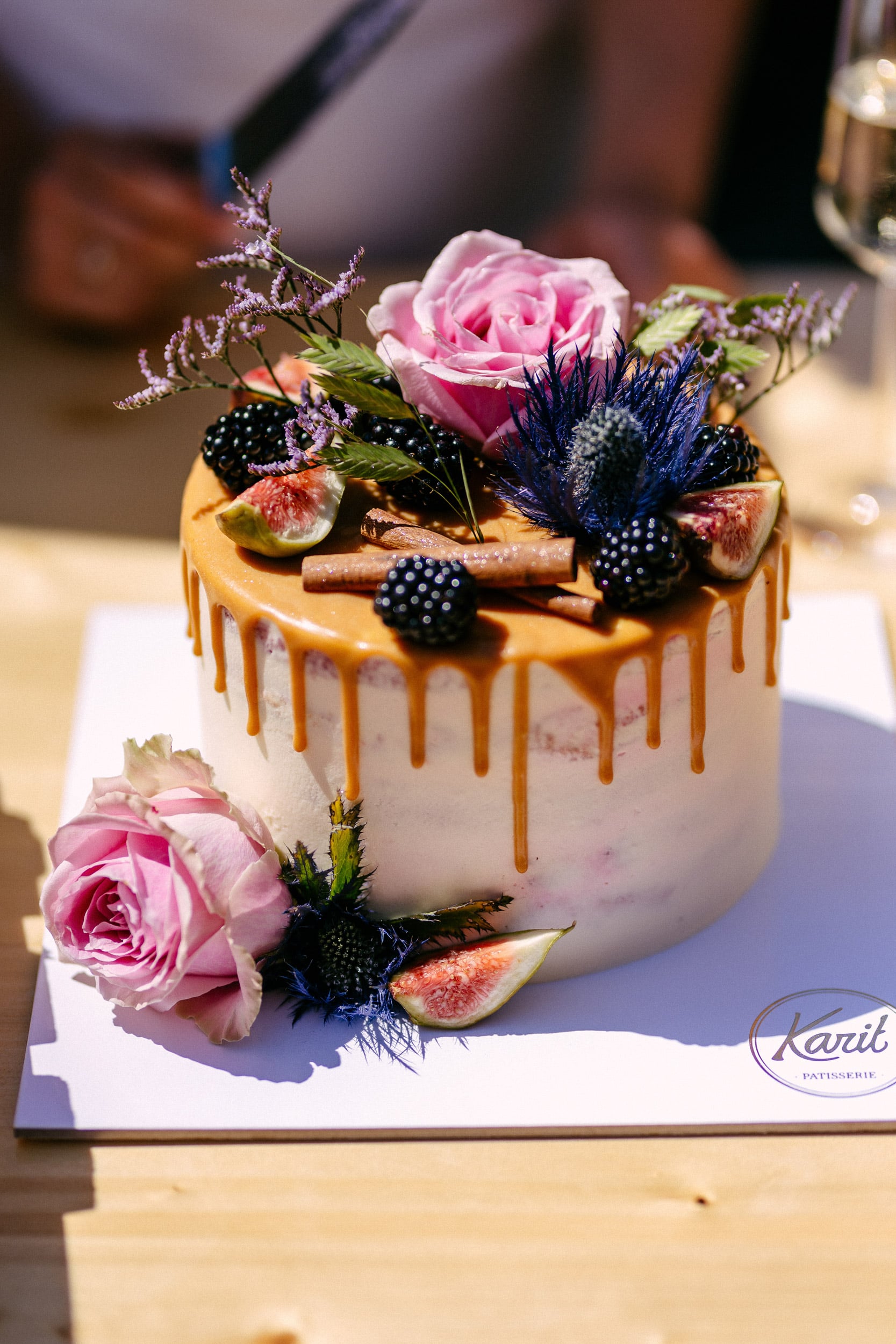 A wedding cake decorated with flowers and berries.