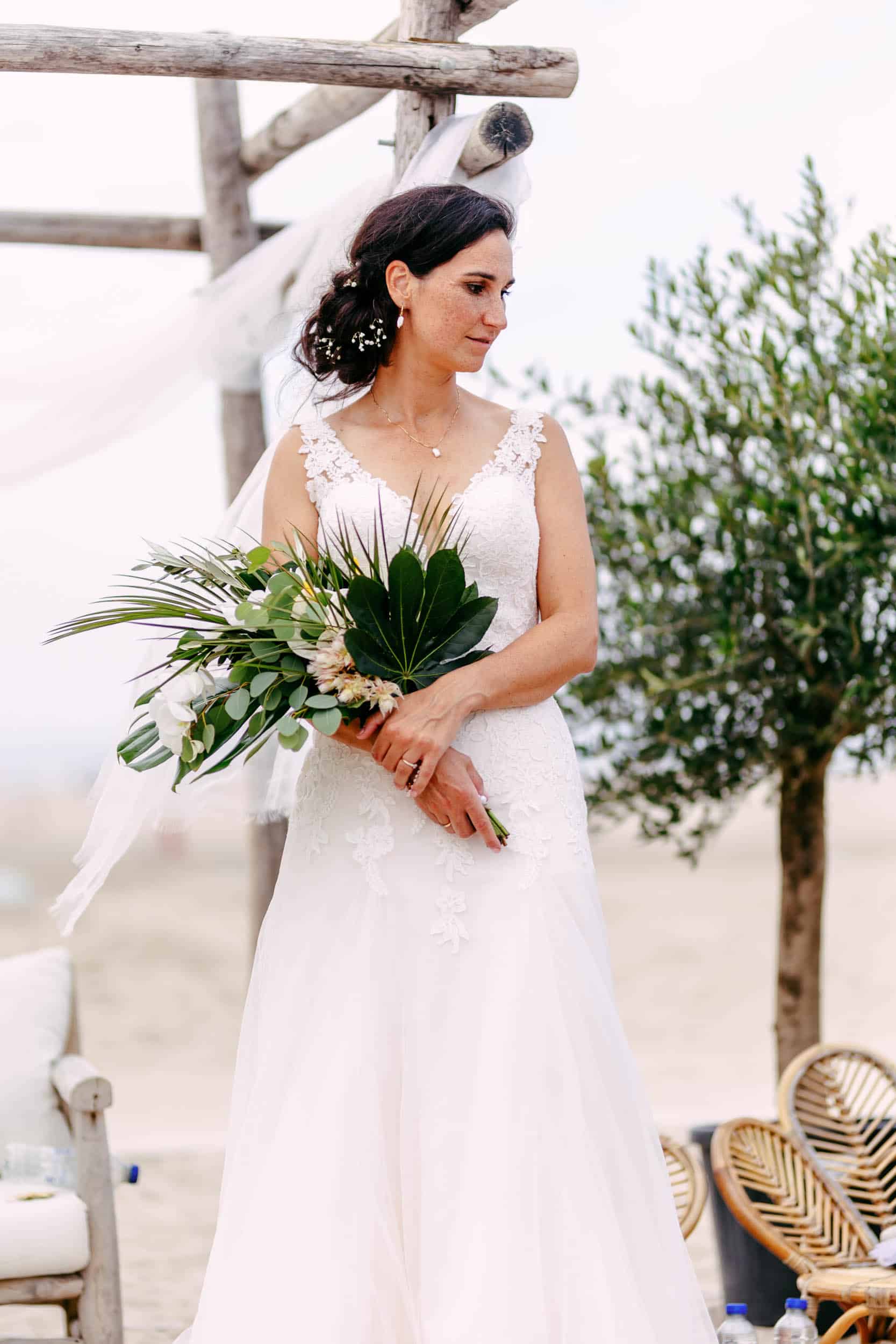 A bride with a wedding bouquet on the beach.