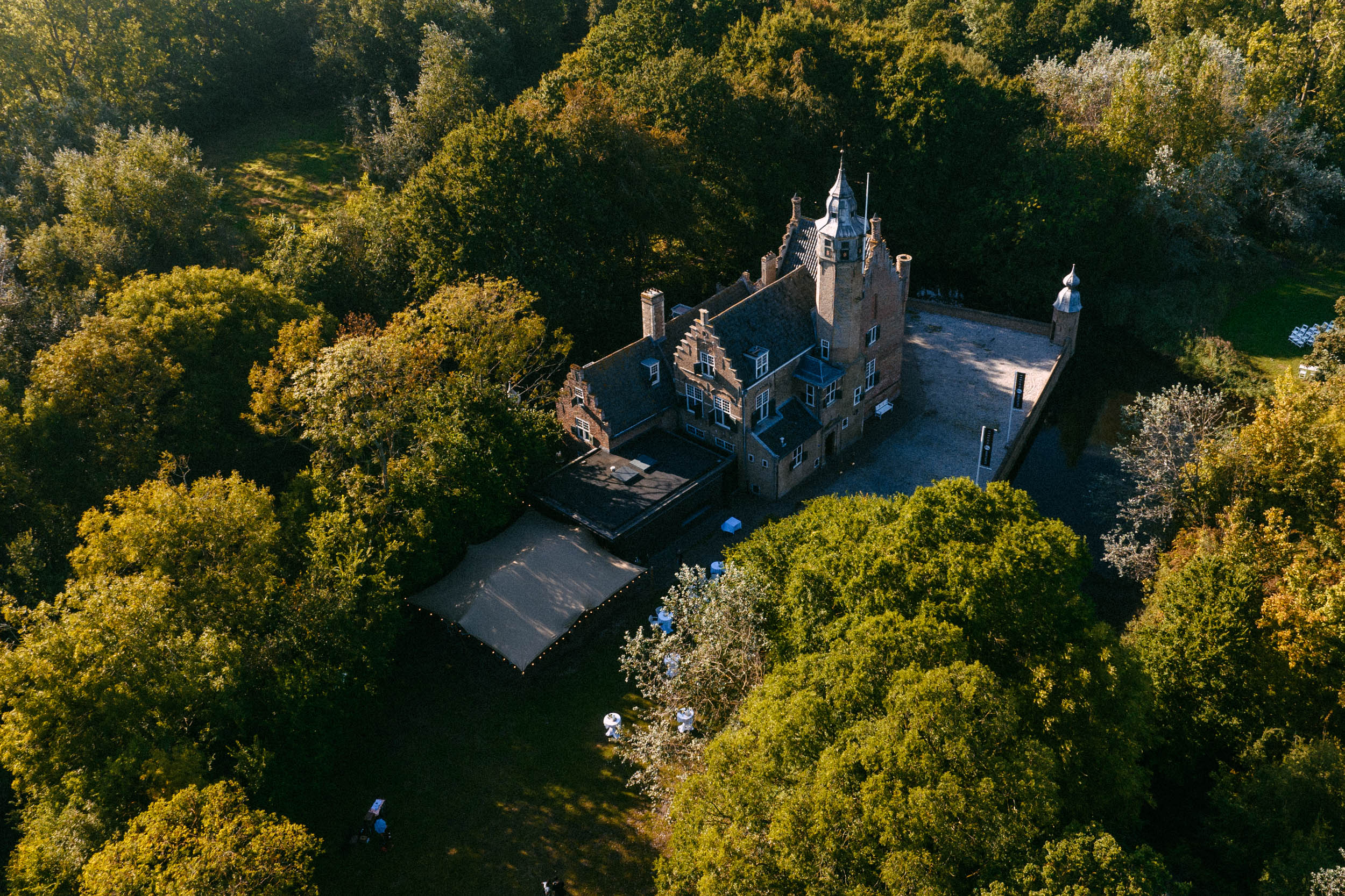 A castle wedding venue set amidst a lush forest, with breathtaking aerial views.