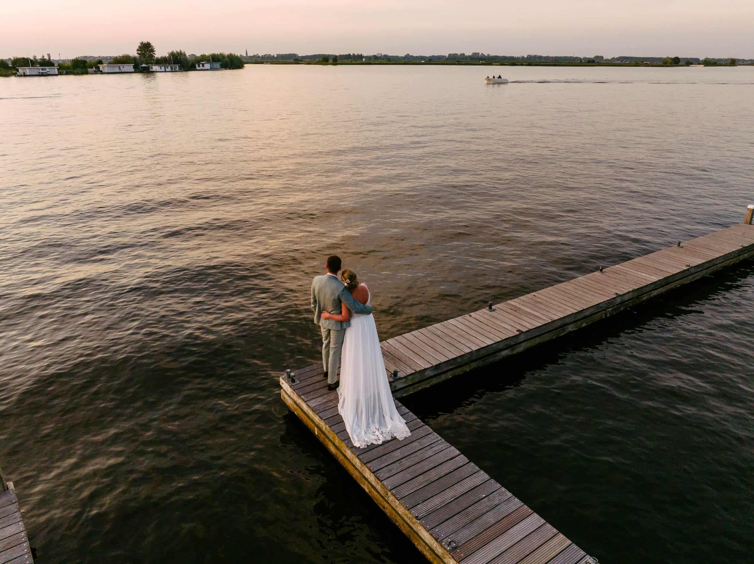 A Waterlust couple standing on a quay at sunset, captured by the Kaag Society.