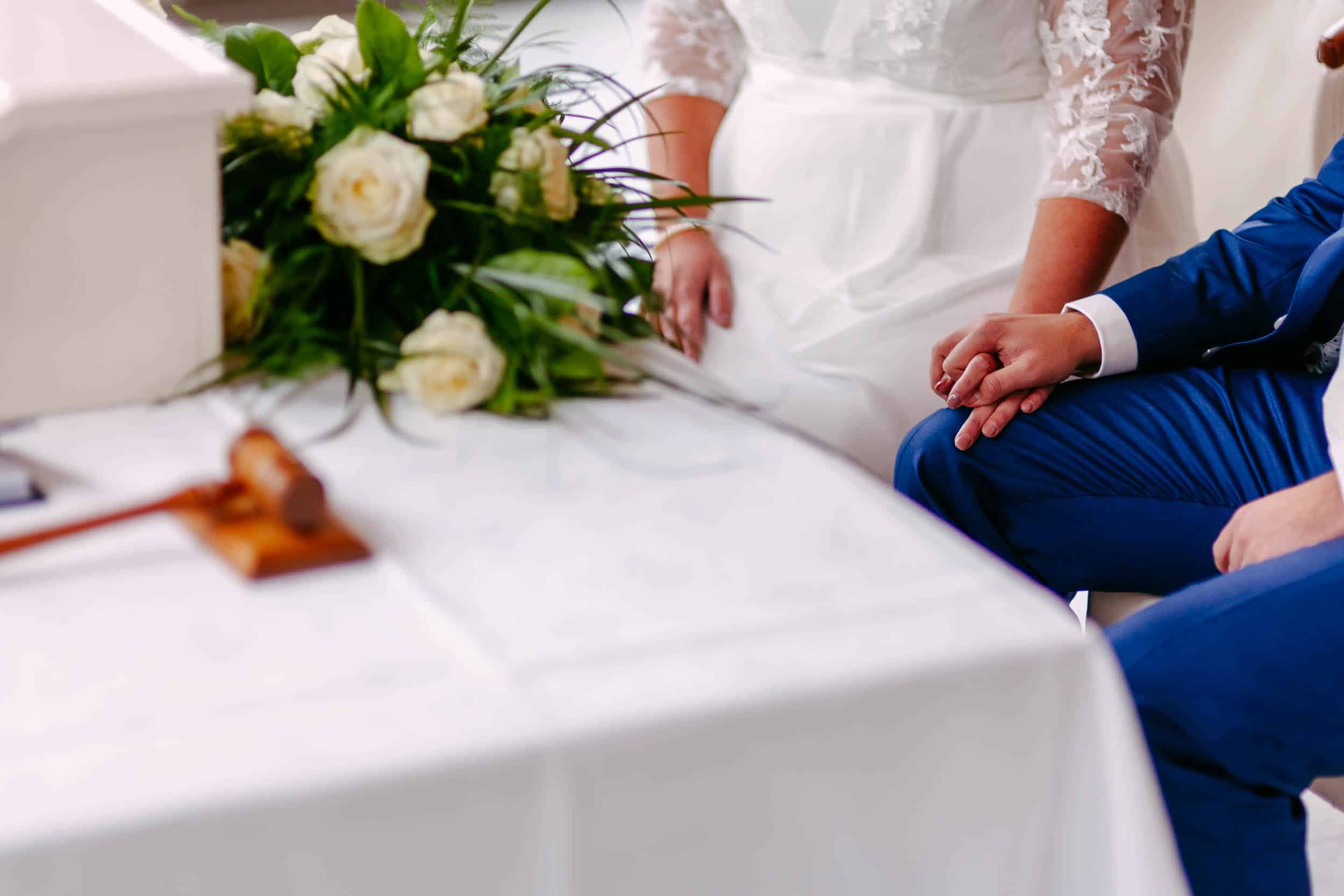 Een bruid en bruidegom zitten tijdens een huwelijksceremonie.