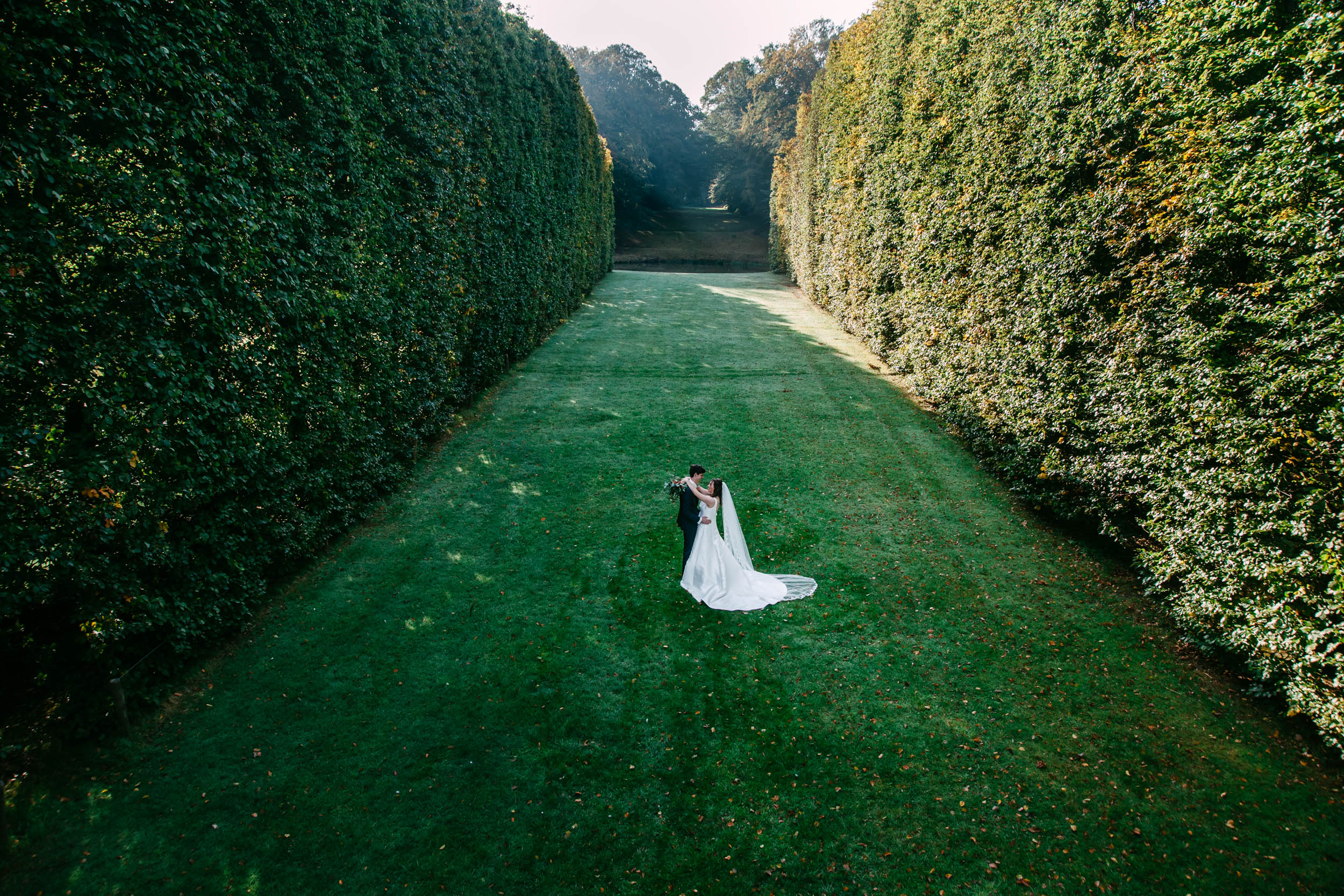 Een bruid en bruidegom staan midden in de Orangerie.