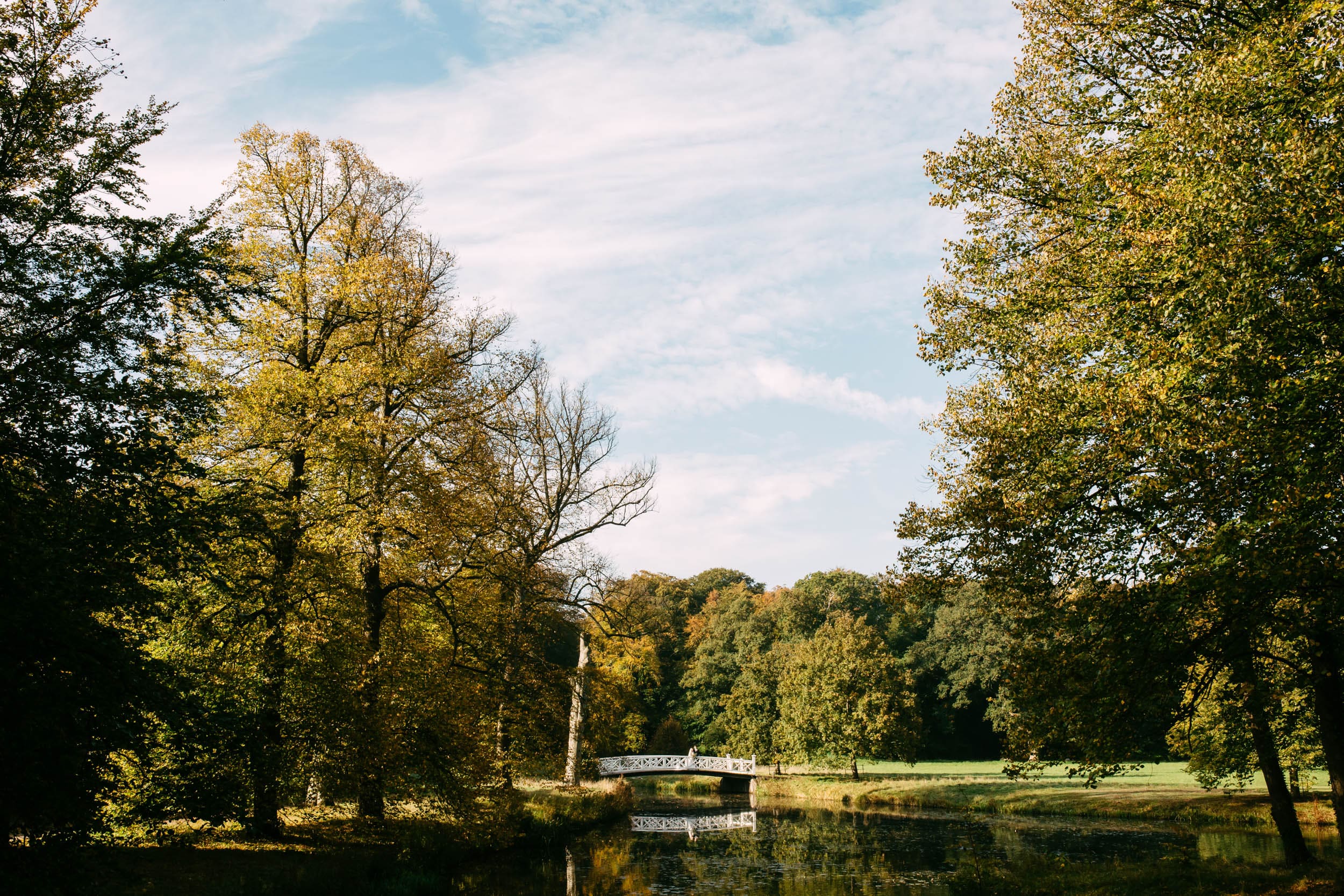 The Orangerie in Elswout is an oasis of tranquillity, with a pond surrounded by lush trees and connected by a charming bridge.