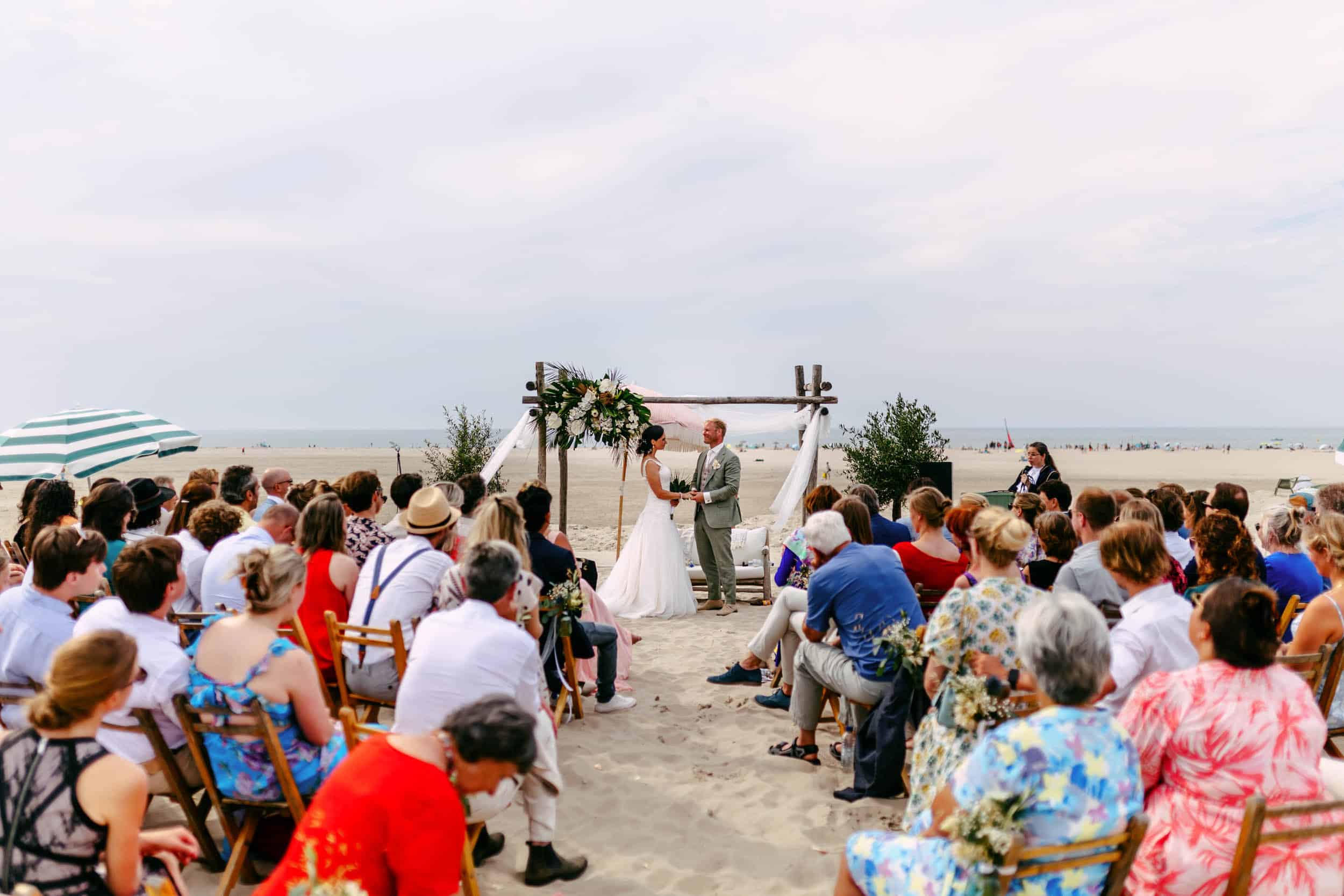 Een Beachclub-huwelijksceremonie waarbij een bruid en bruidegom hun geloften uitspreken terwijl ze omringd worden door de rustgevende geluiden van vogels.