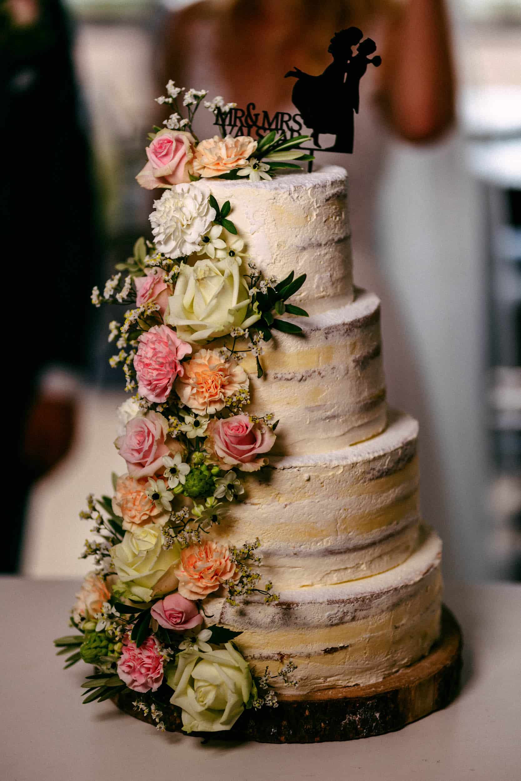 A wedding cake with the silhouette of a bride and groom, inspired by the unique charm of My torpedo shed.