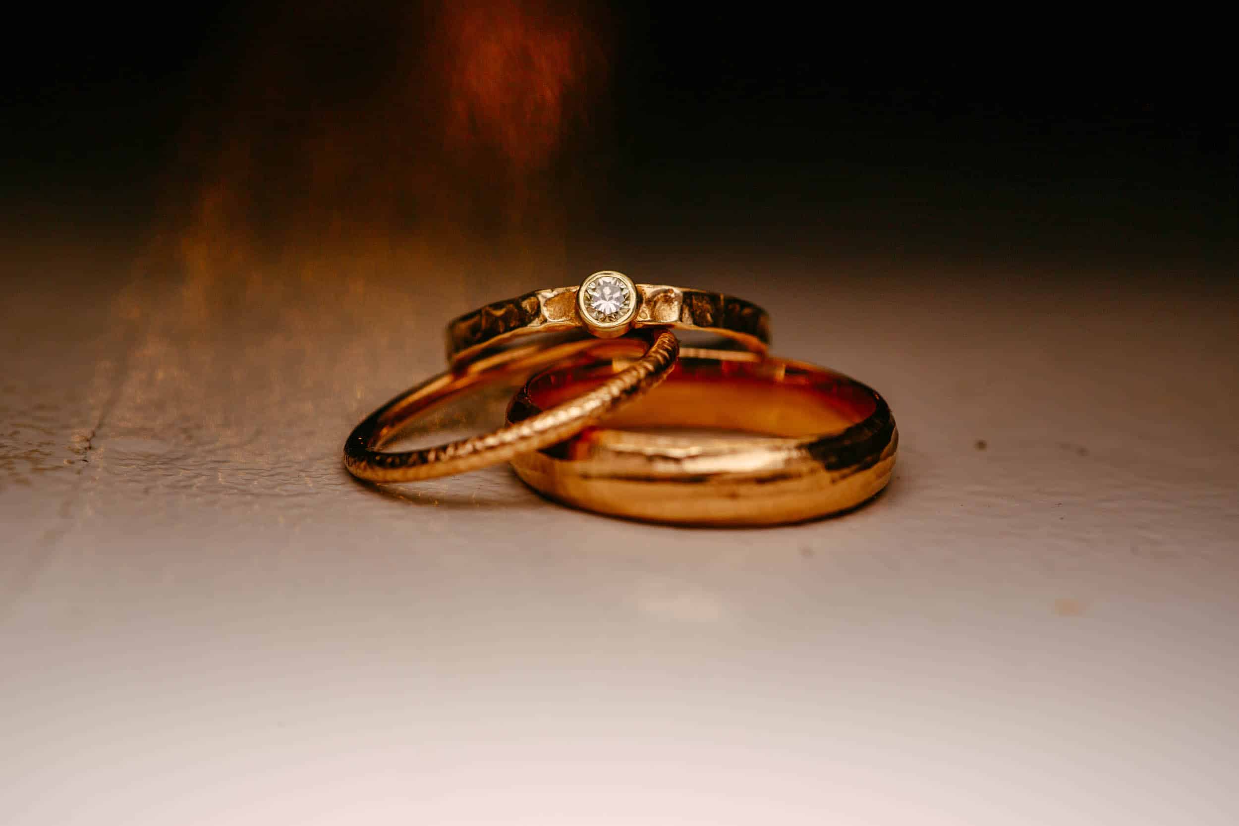 A pair of gold wedding rings on a table.