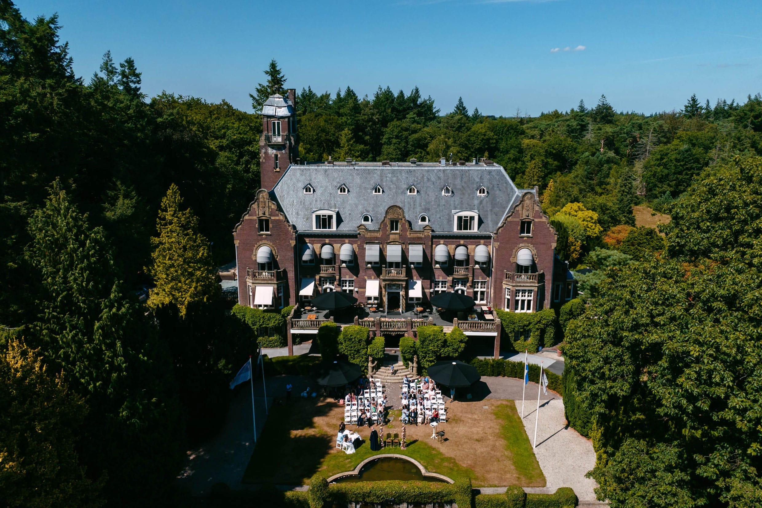 An aerial view of the beautiful Castle de Hooge Vuursche surrounded by trees.
