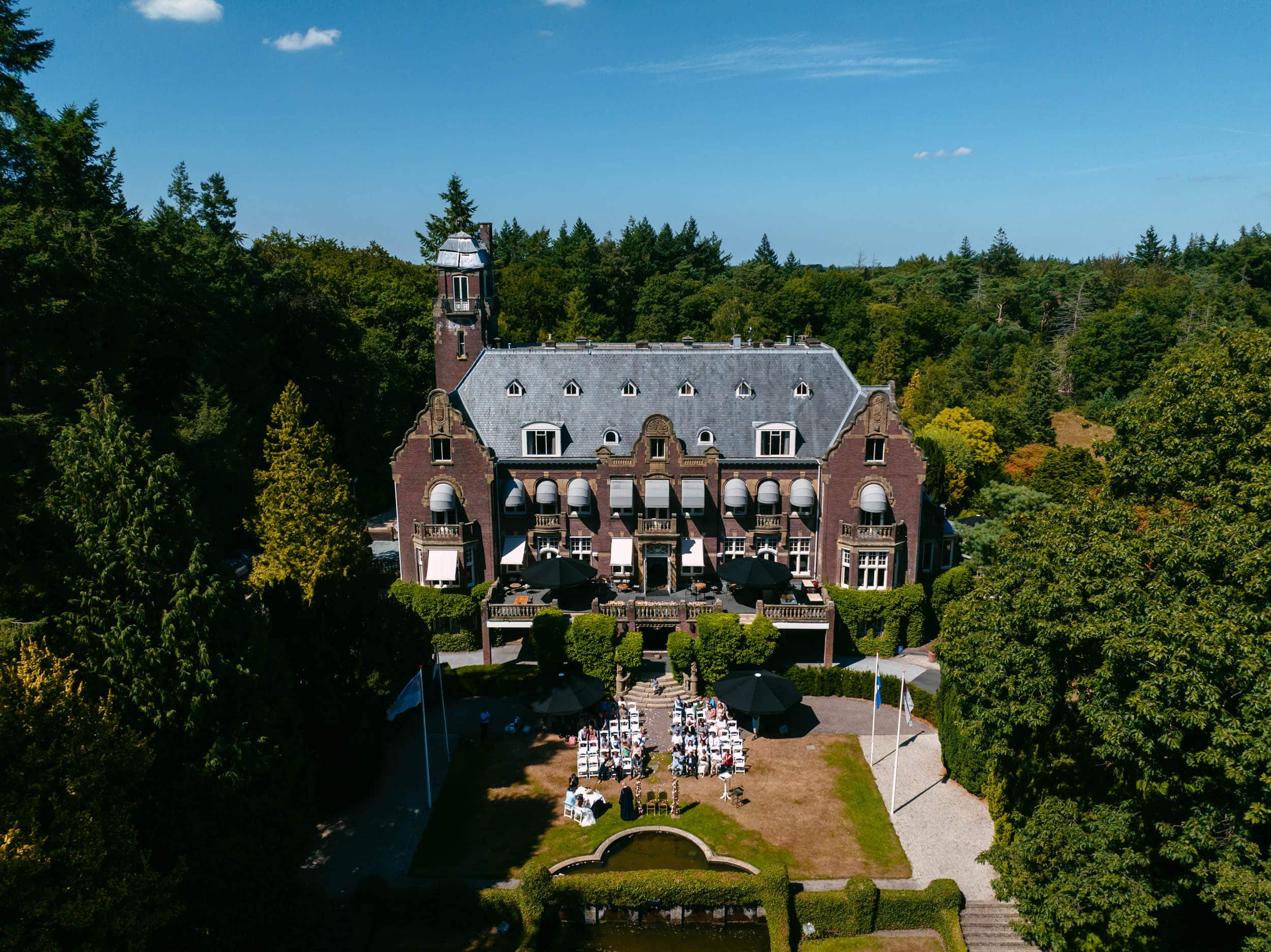 An aerial view of a large mansion surrounded by trees.